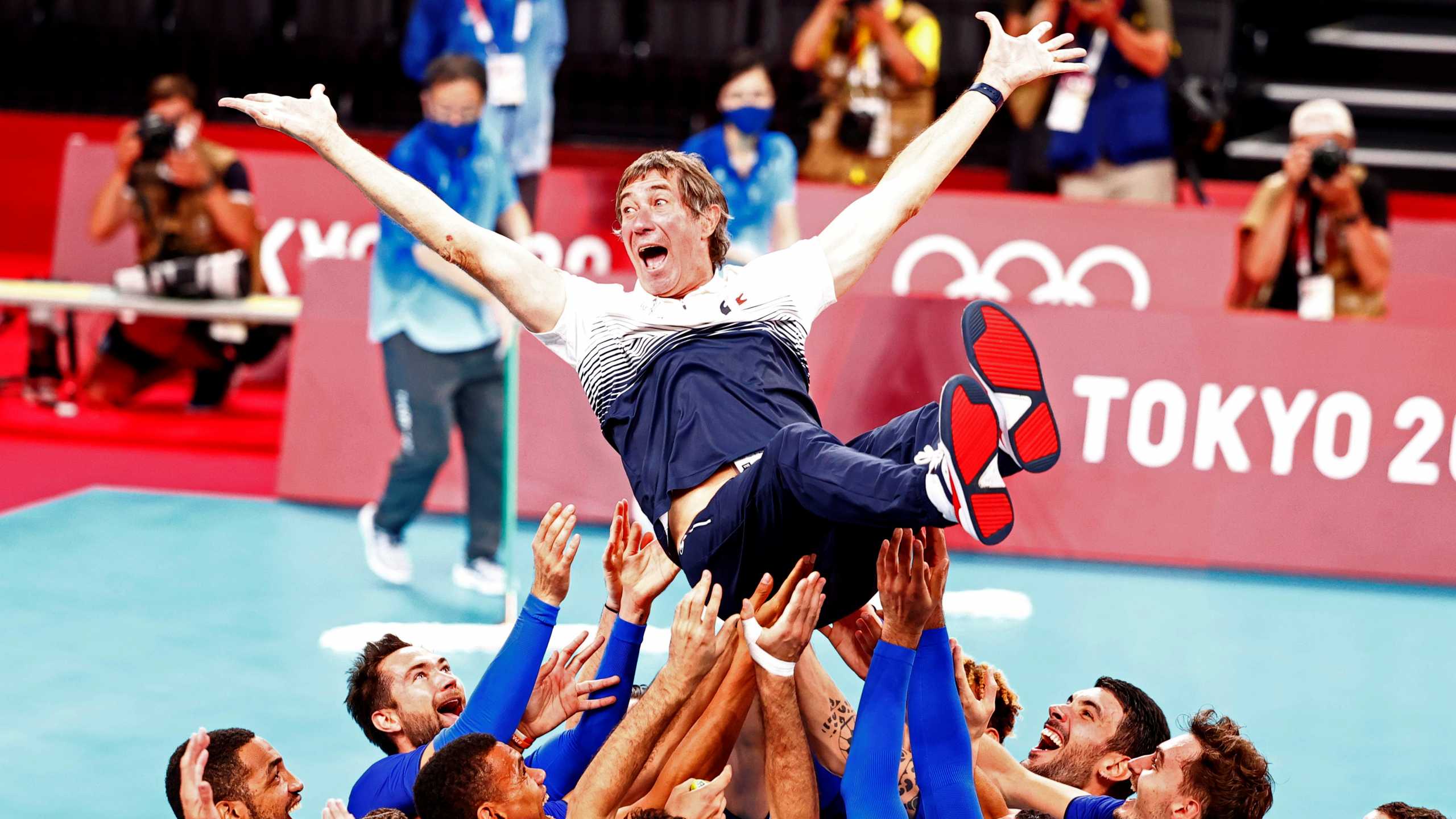 Tokyo 2020 Olympics - Volleyball - Men's Gold medal match - France v The Russian Olympic Committee - Ariake Arena, Tokyo, Japan – August 7, 2021. France coach Laurent Tillie is thrown into the air by team members as they celebrate after winning gold. REUTERS