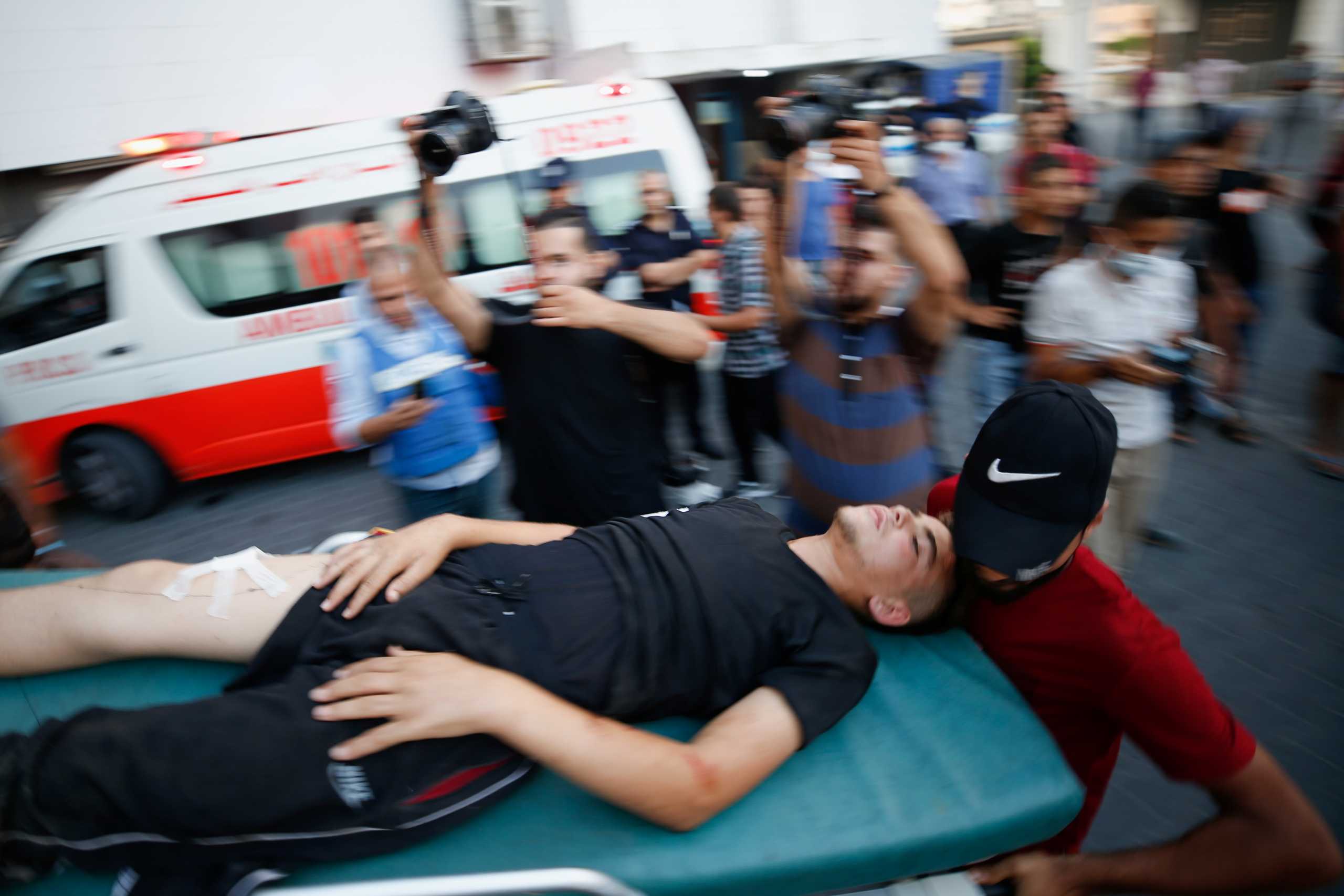 A wounded Palestinian is carried on a stretcher after taking part in a protest at Israel-Gaza border east of Gaza City, August 21, 2021. REUTERS