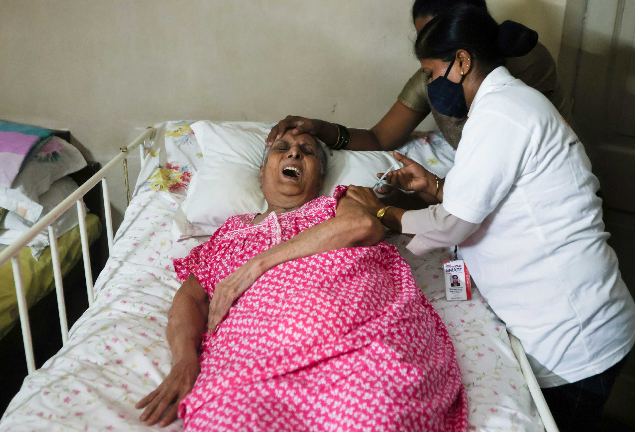 Mehroo Jal Langrama, 80, reacts as she receives a dose of COVAXIN coronavirus disease (COVID-19) vaccine manufactured by Bharat Biotech, at her home in Mumbai, India, August 5, 2021. REUTERS