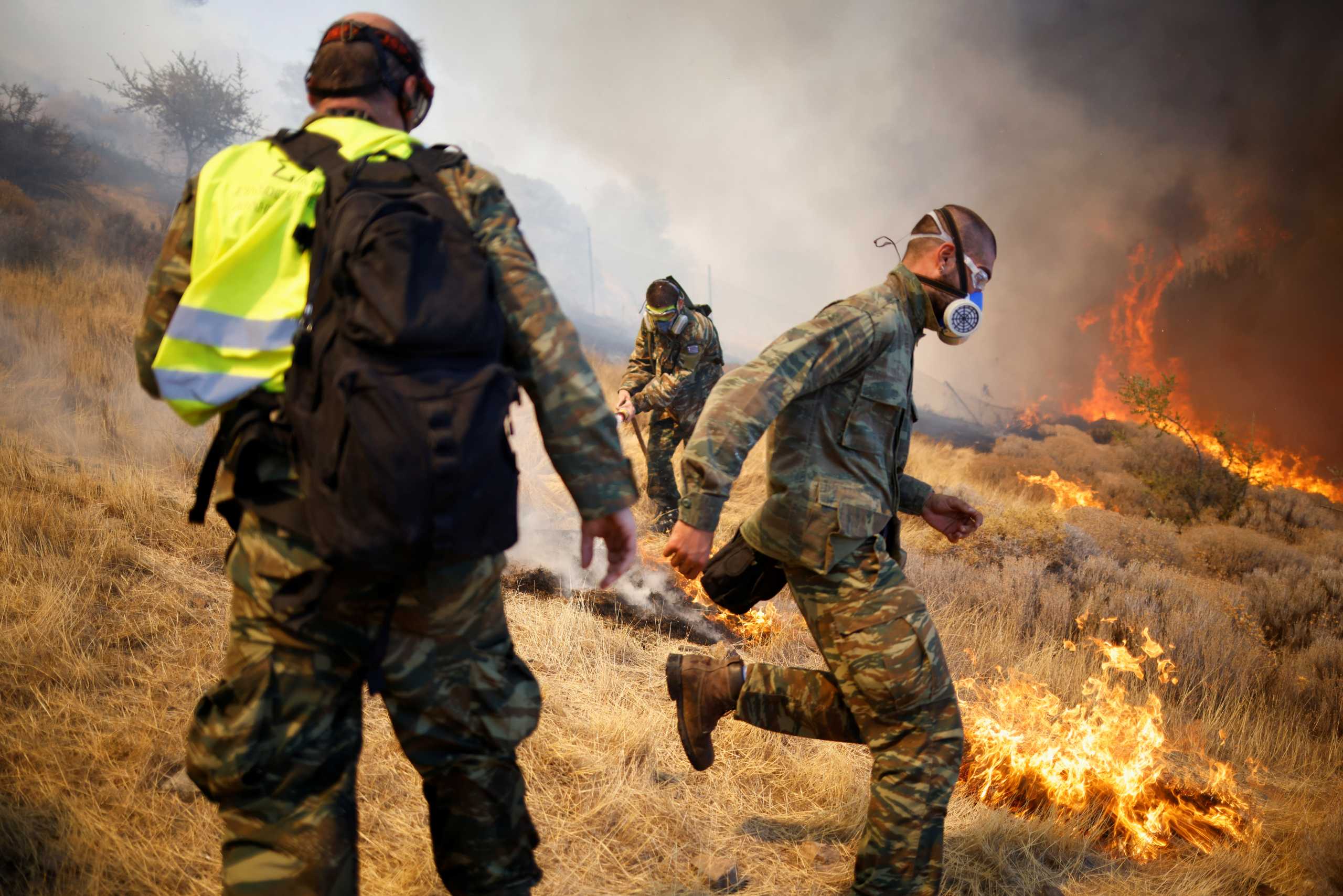 Volunteers try to extinguish a wildfire burning in the village of Markati, near Athens, Greece, August 16, 2021. REUTERS