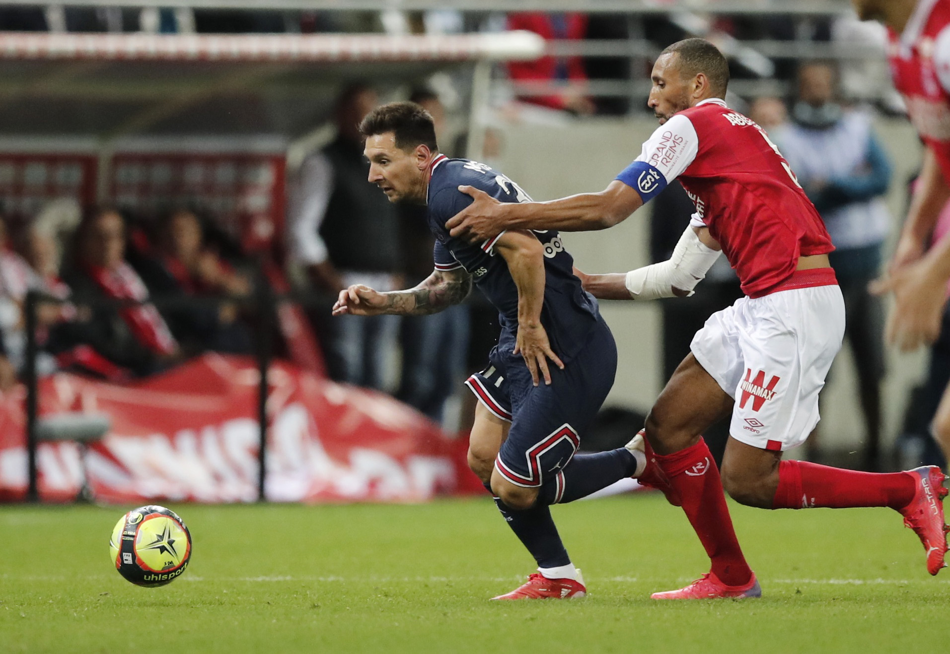 Soccer Football - Ligue 1 - Stade de Reims v Paris St Germain - Stade Auguste-Delaune, Reims, France - August 29, 2021 Paris St Germain's Lionel Messi in action with Stade de Reims' Yunis Abdelhamid REUTERS