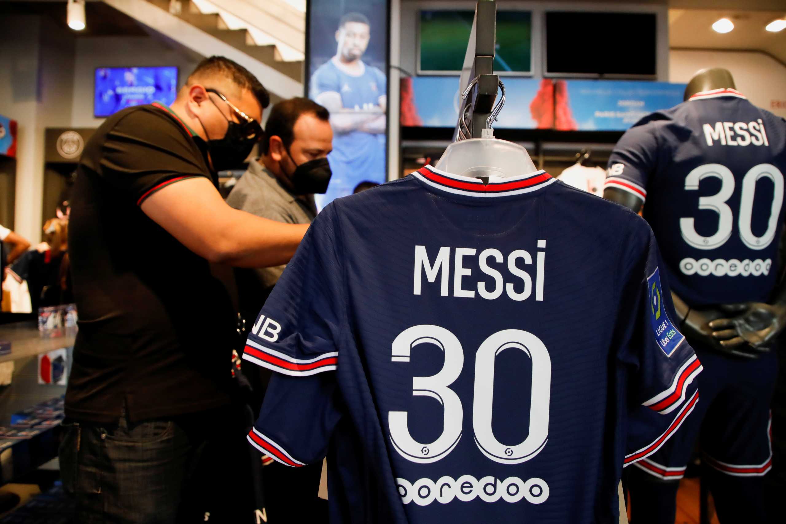 Fans buy Paris St Germain Lionel Messi football jerseys inside a Paris St Germain shop in Paris, France, August 11, 2021. REUTERS