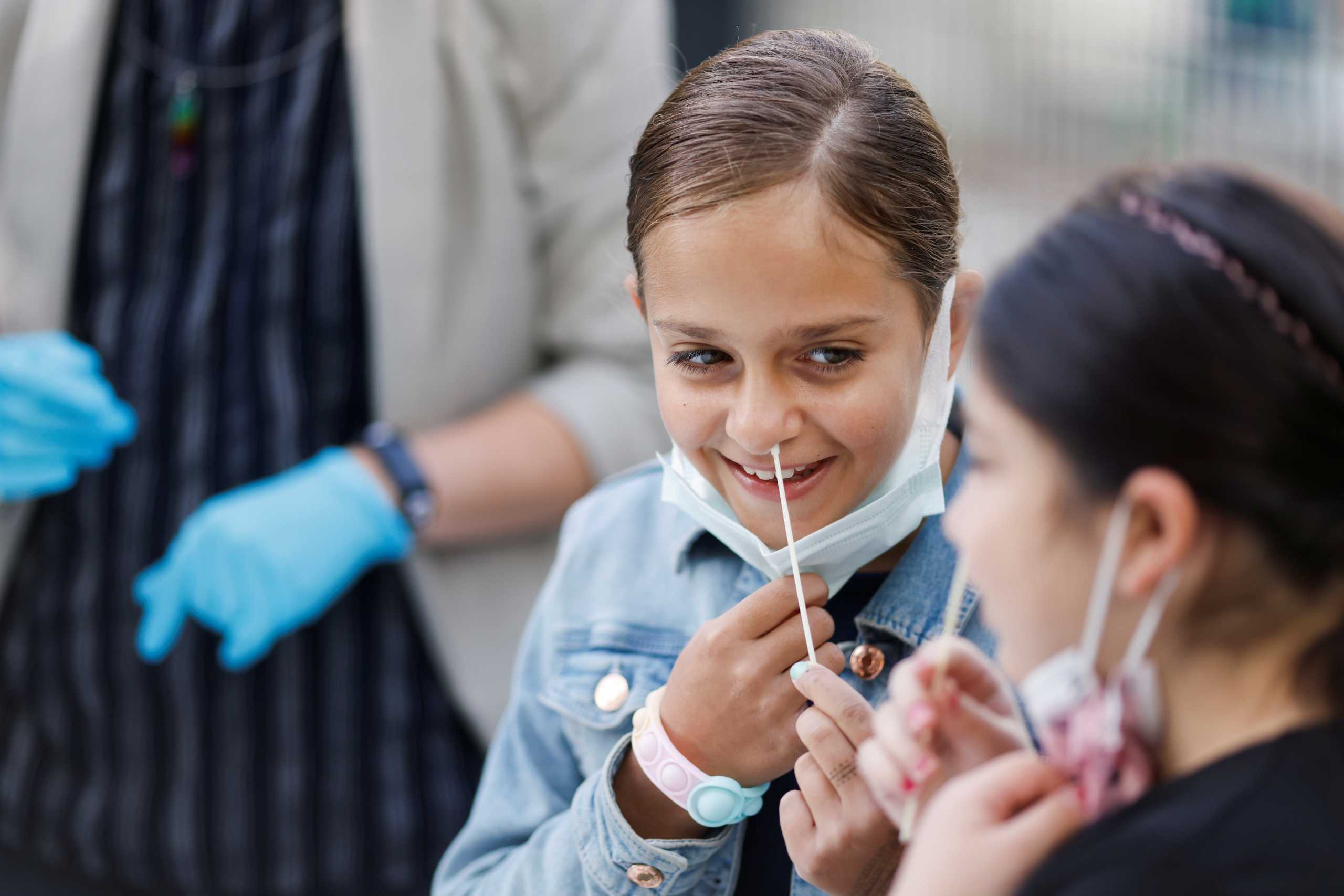 A student performs a COVID-19 quick test, as students return to regular presence schooling, amid the spread of the coronavirus disease (COVID-19) in Berlin, Germany, August 9, 2021. REUTERS