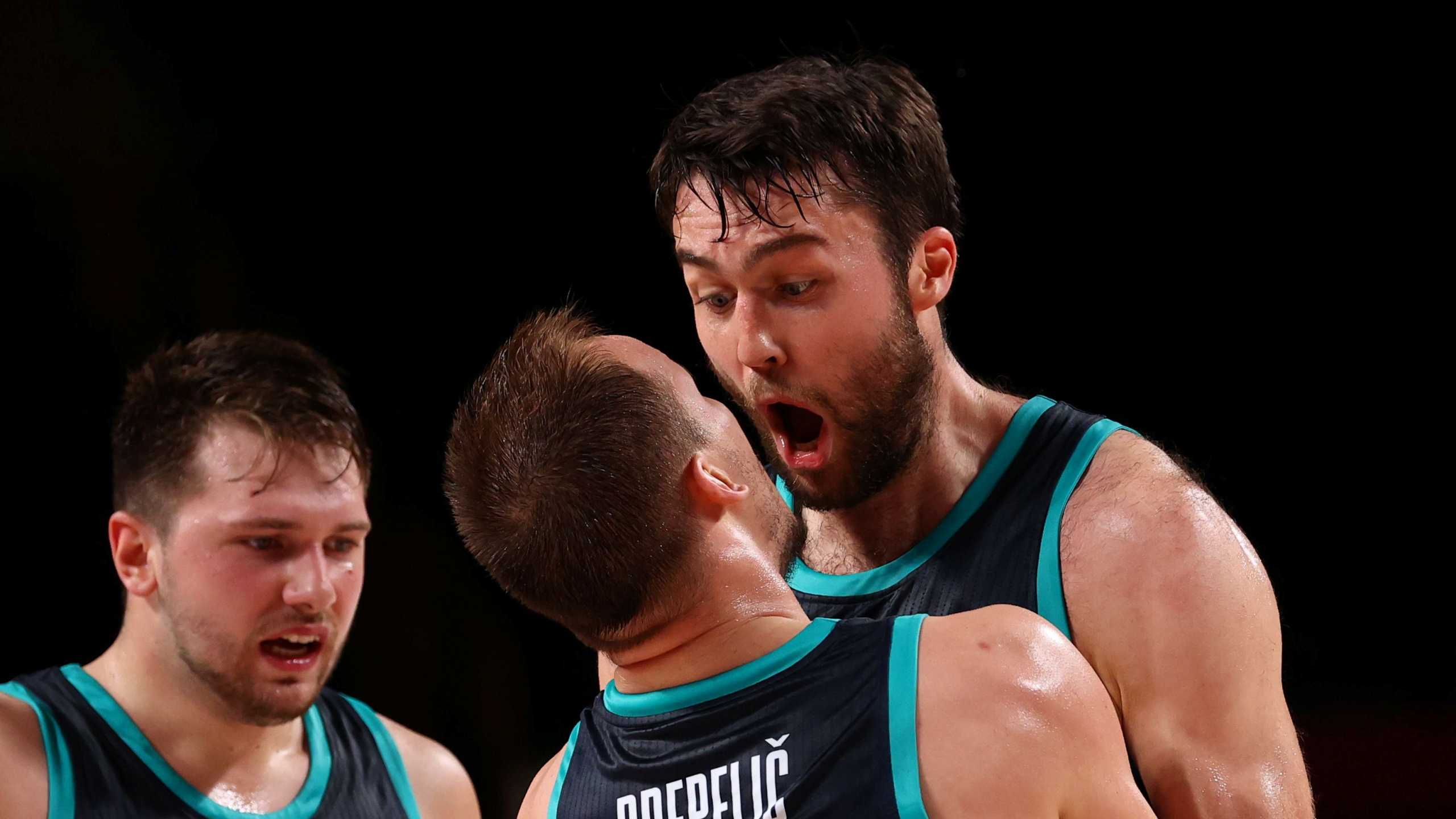 Tokyo 2020 Olympics - Basketball - Men - Group C - Spain v Slovenia - Saitama Super Arena, Saitama, Japan - August 1, 2021. Luka Doncic of Slovenia with Klemen Prepelic of Slovenia and Mike Tobey of Slovenia celebrate after scoring a basket REUTERS