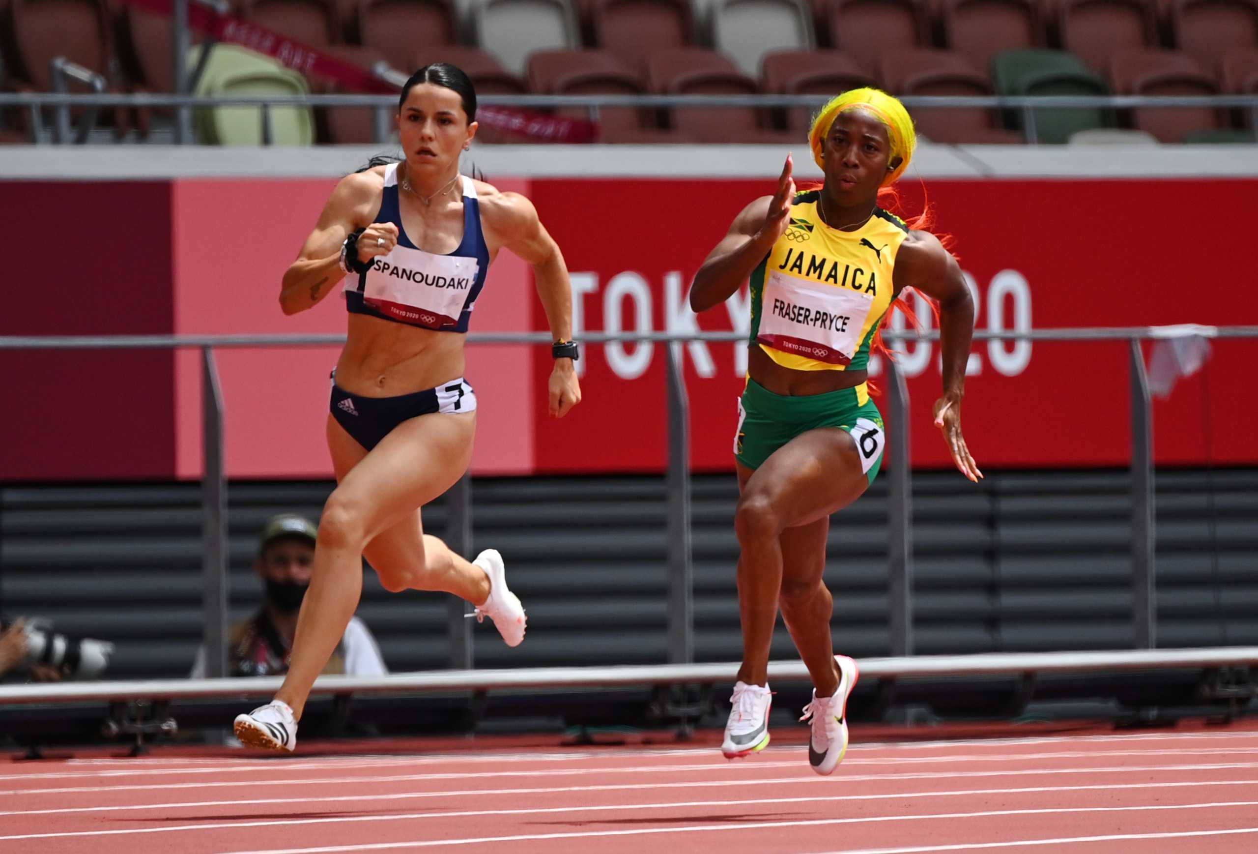 Tokyo 2020 Olympics - Athletics - Women's 200m - Round 1 - Olympic Stadium, Tokyo, Japan - August 2, 2021. Shelly-Ann Fraser-Pryce of Jamaica and Rafailia Spanoudaki-Hatziriga of Greece in action during Heat 2 REUTERS