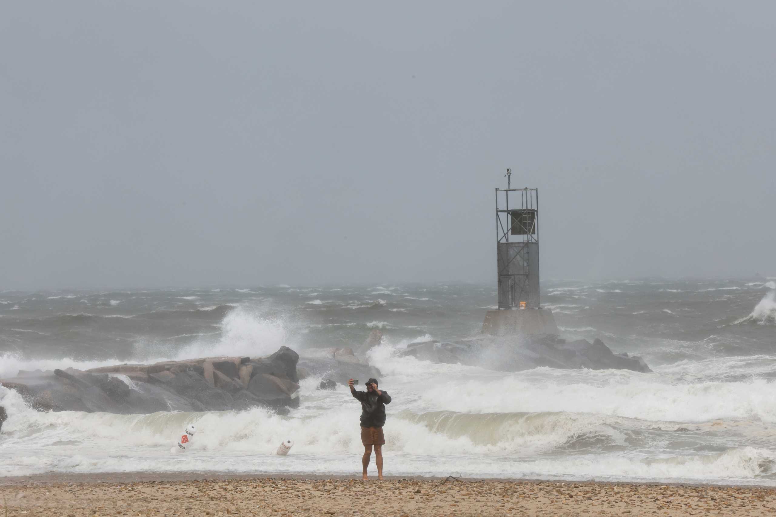 A person takes a selfie on the beach during Tropical Storm Henri in Montauk, New York, U.S., August 22, 2021. REUTERS