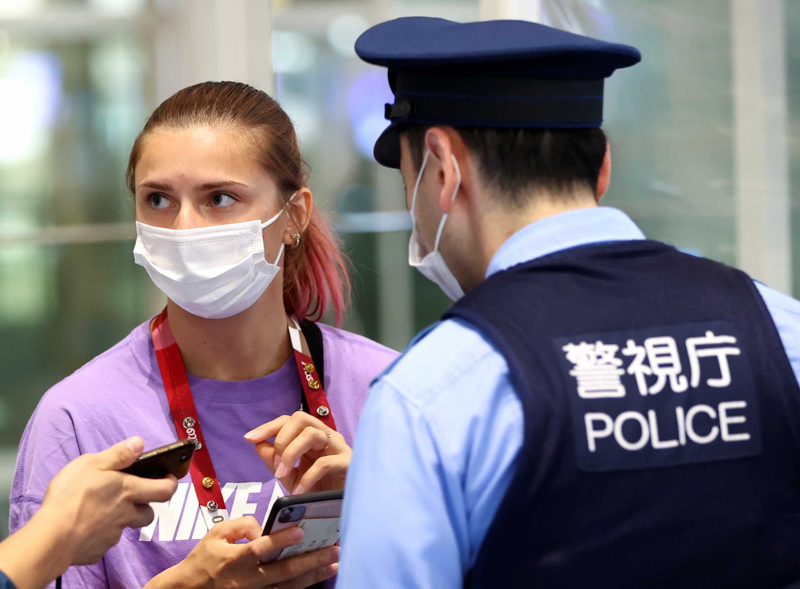 Belarusian sprinter Krystsina Tsimanouskaya talks with police officers at Haneda international airport in Tokyo, Japan August 1, 2021.  REUTERS