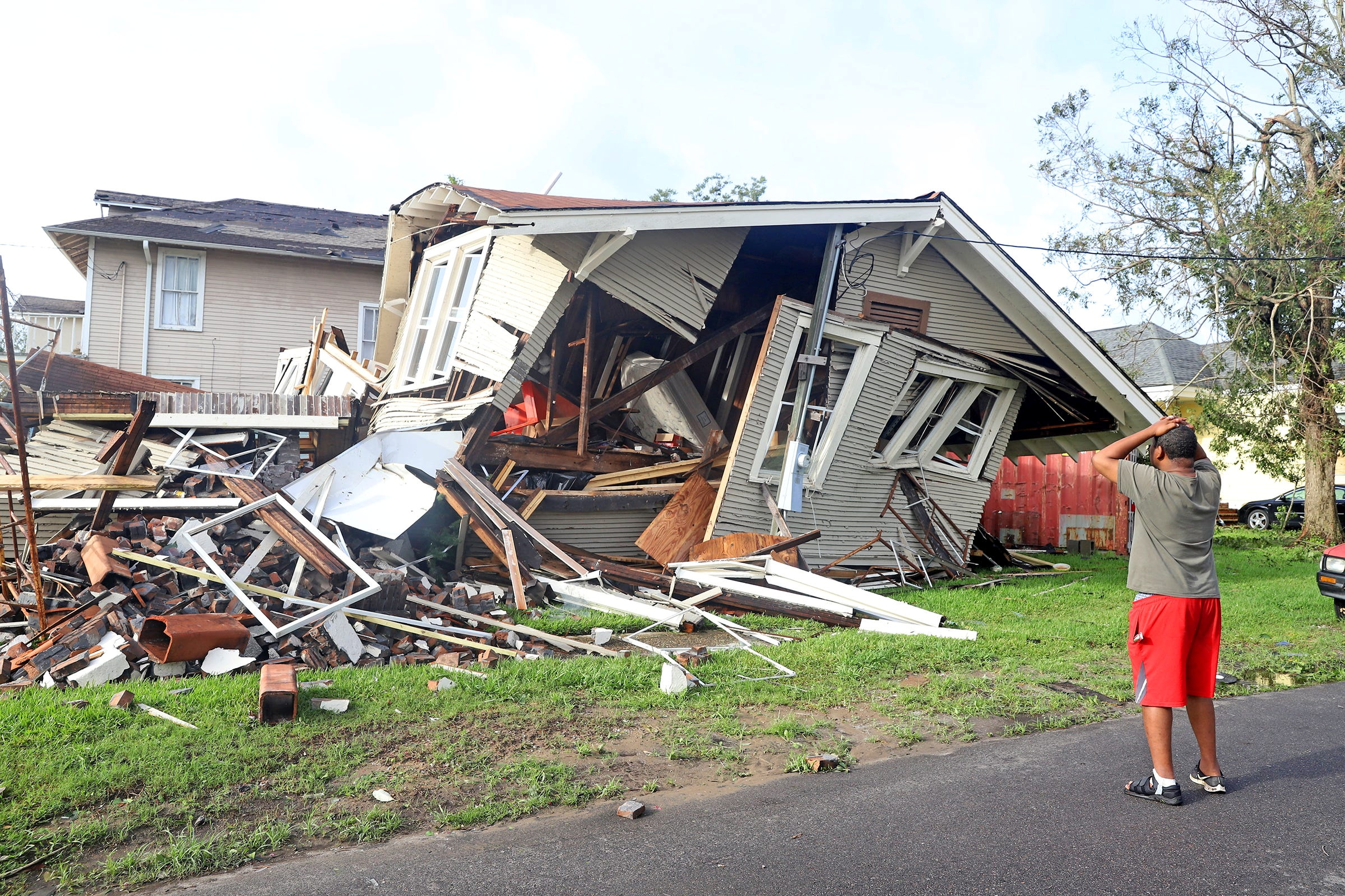 Dartanian Stovall looks at the house that collapsed with him inside during the height of Hurricane Ida in New Orleans, Louisiana, U.S., August 30, 2021. Stovall said he was inside the house he was renovating on Lasalle Street in the Uptown neighborhood when the chimney collapsed and the rest of the house followed. He managed to crawl to safety. Michael DeMocker