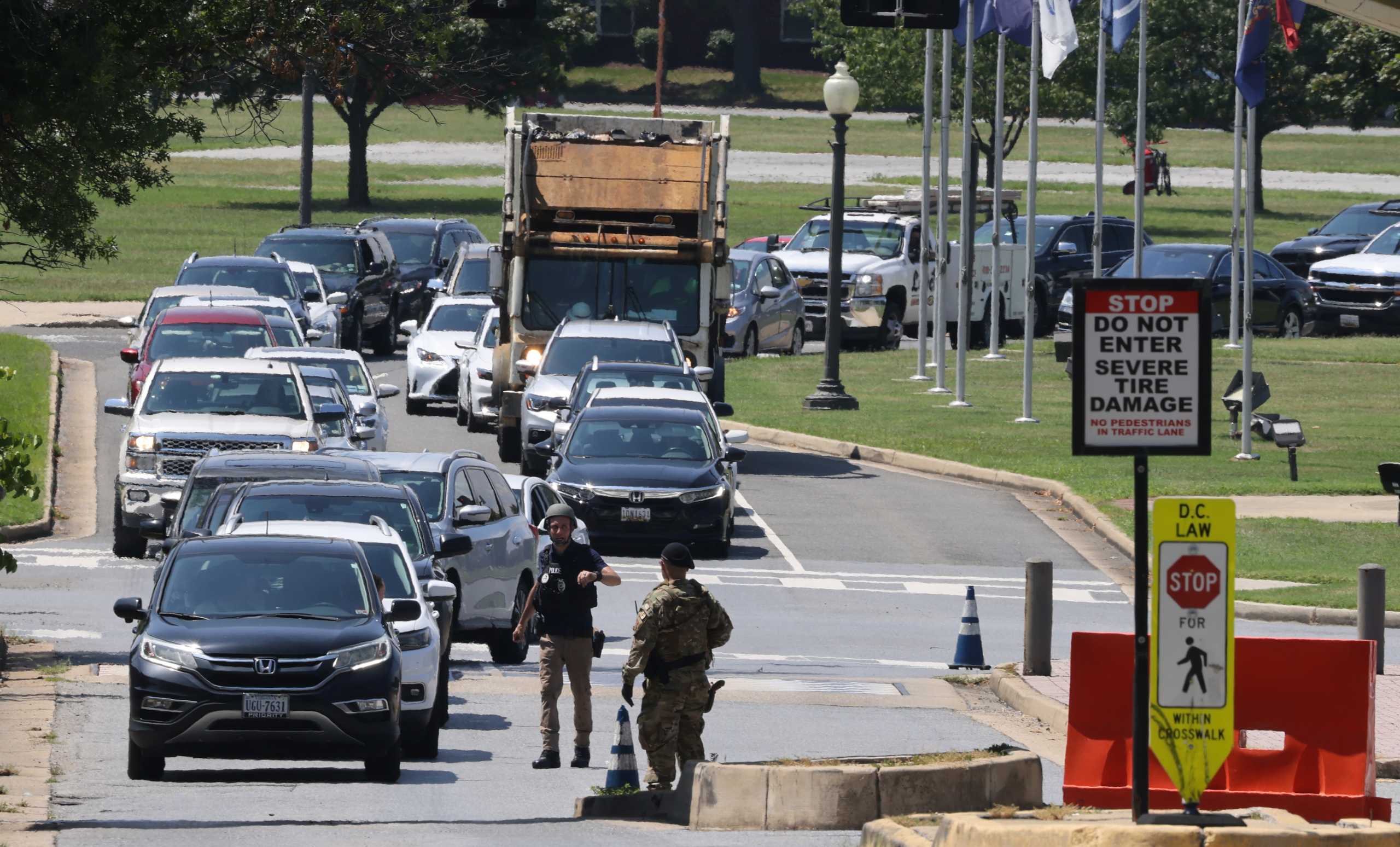 Military police officers direct traffic off Joint Base Anacostia-Bolling after the U.S. military base was put on lockdown due to a report of a suspicious armed person on site in Washington, U.S., August 13, 2021.   REUTERS