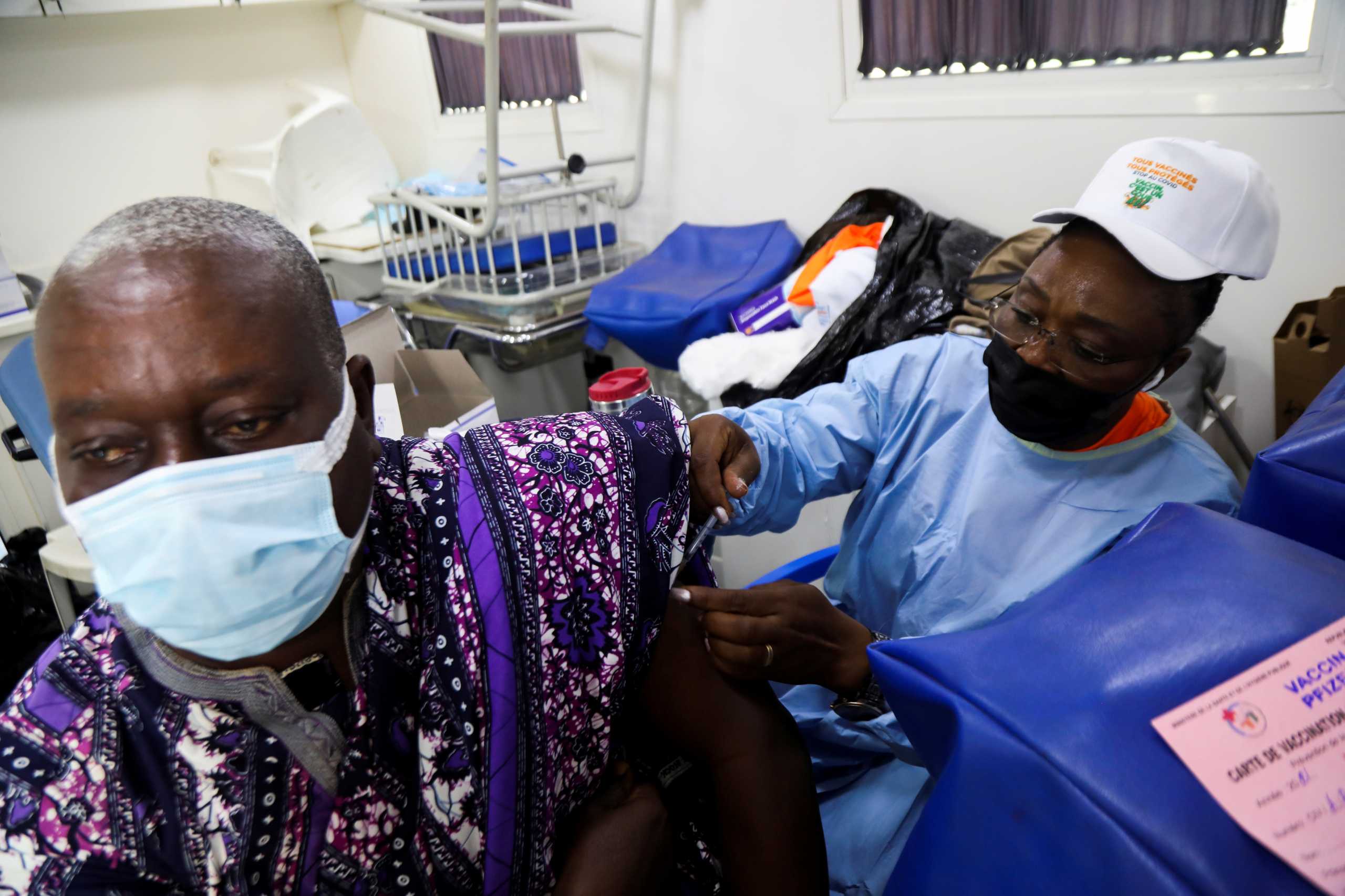 FILE PHOTO: An Ivorian traditional chief receives a vaccine against the coronavirus disease (COVID-19) in a vaccination truck during the visit of Sandra Kramer, director for Africa at the Directorate General for International Partnerships (INTPA) of the European Commission, and Maria Shaw-Barragan, director of international operations at the European Investment Bank (EIB), at a mobile vaccination center in Abidjan, Ivory Coast September 23, 2021. REUTERS