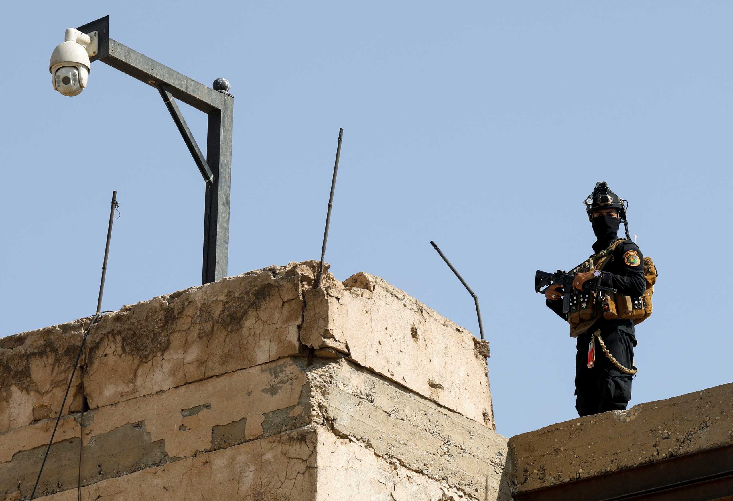 A member of security forces stands guard ahead of the arrival of French President Emmanuel Macron at Al-Sa'ah church in the Old City of Mosul, Iraq, August 29, 2021. REUTERS
