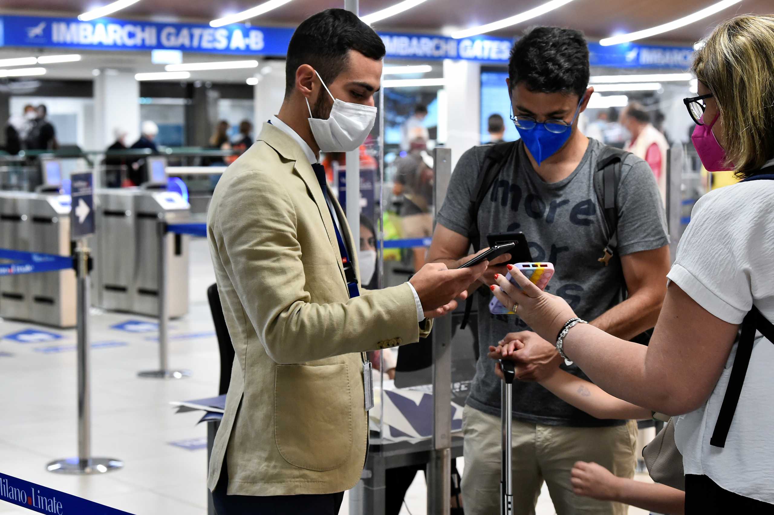 People show their digital COVID-19 certificates at Linate Airport in Milan, Italy, September 1, 2021. REUTERS
