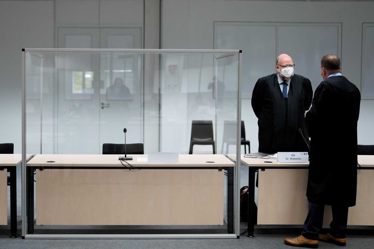The defendant's lawyer Wolf Molkentin speaks to a man next to the empty seat of the accused 96-year-old former secretary to the SS commander of the Stutthof concentration camp, at the Landgericht Itzehoe court, before a trial against her, in Itzehoe, Germany, September 30, 2021. Markus Schreiber