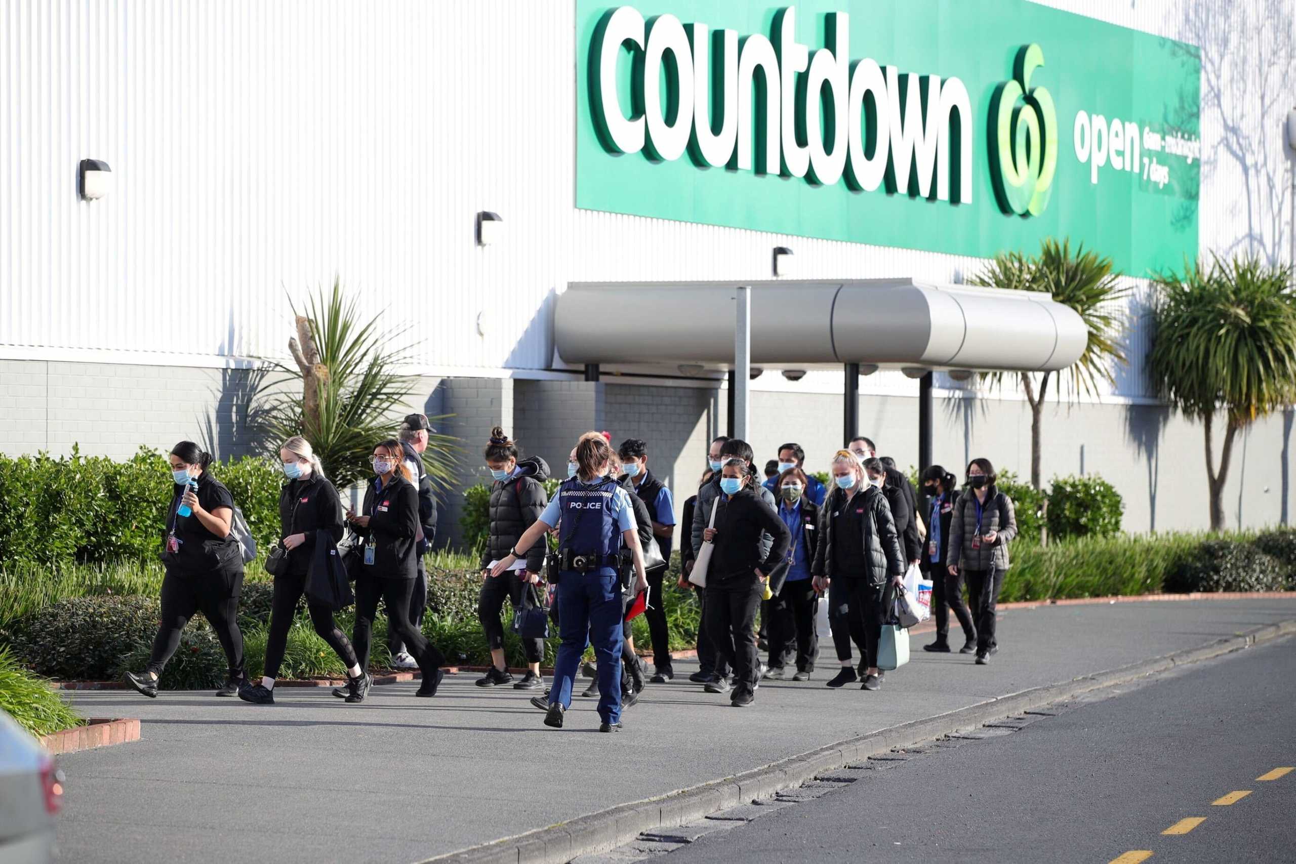 FILE PHOTO: A police officer leads employees of a nearby store away from the scene of an attack carried out by a man who injured multiple people at a shopping mall in Auckland, New Zealand, September 3, 2021.  Stuff Limited