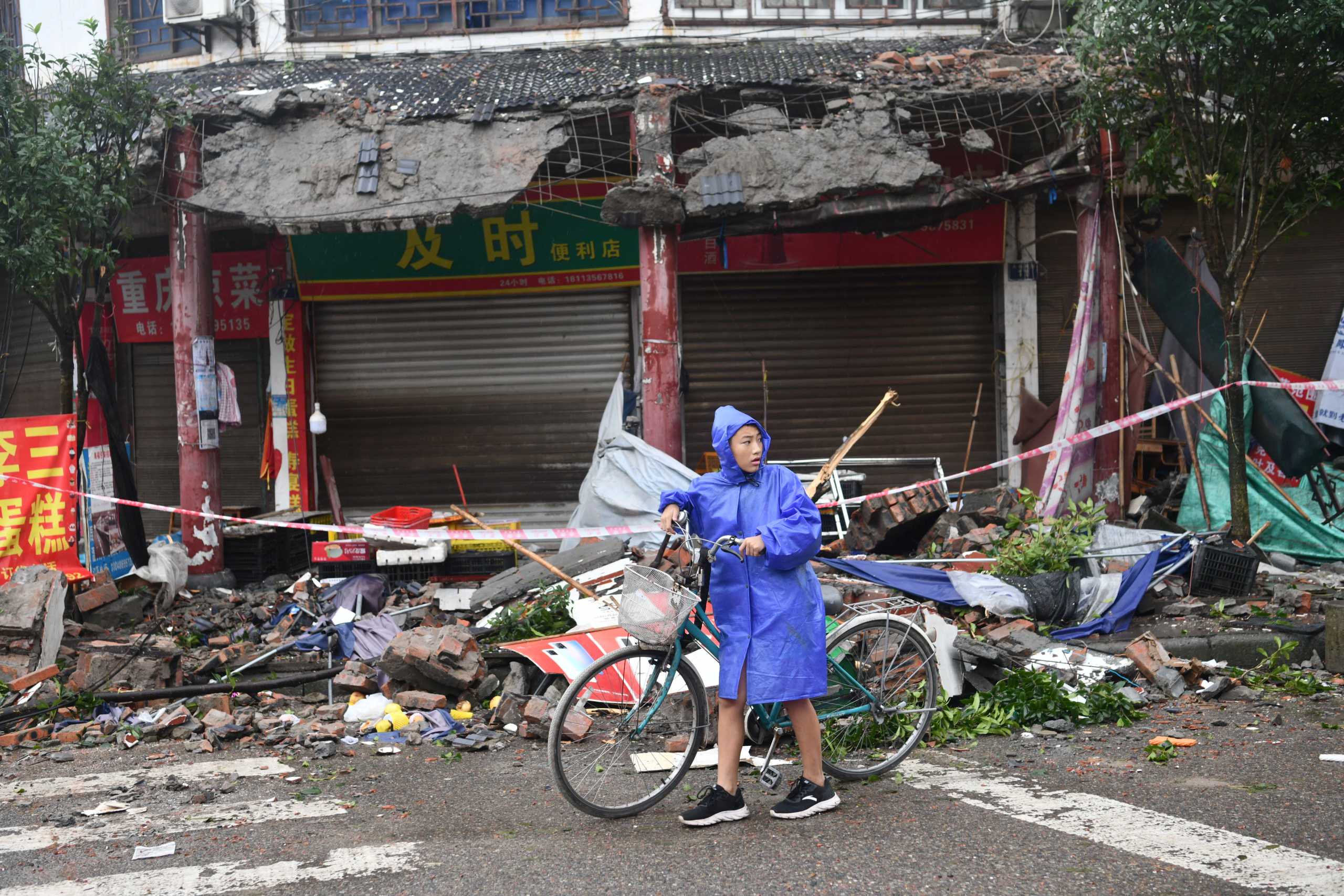 A person pushes a bicycle past damaged buildings, following an earthquake in Luzhou city of southwestern province of Sichuan, China September 16, 2021. cnsphoto