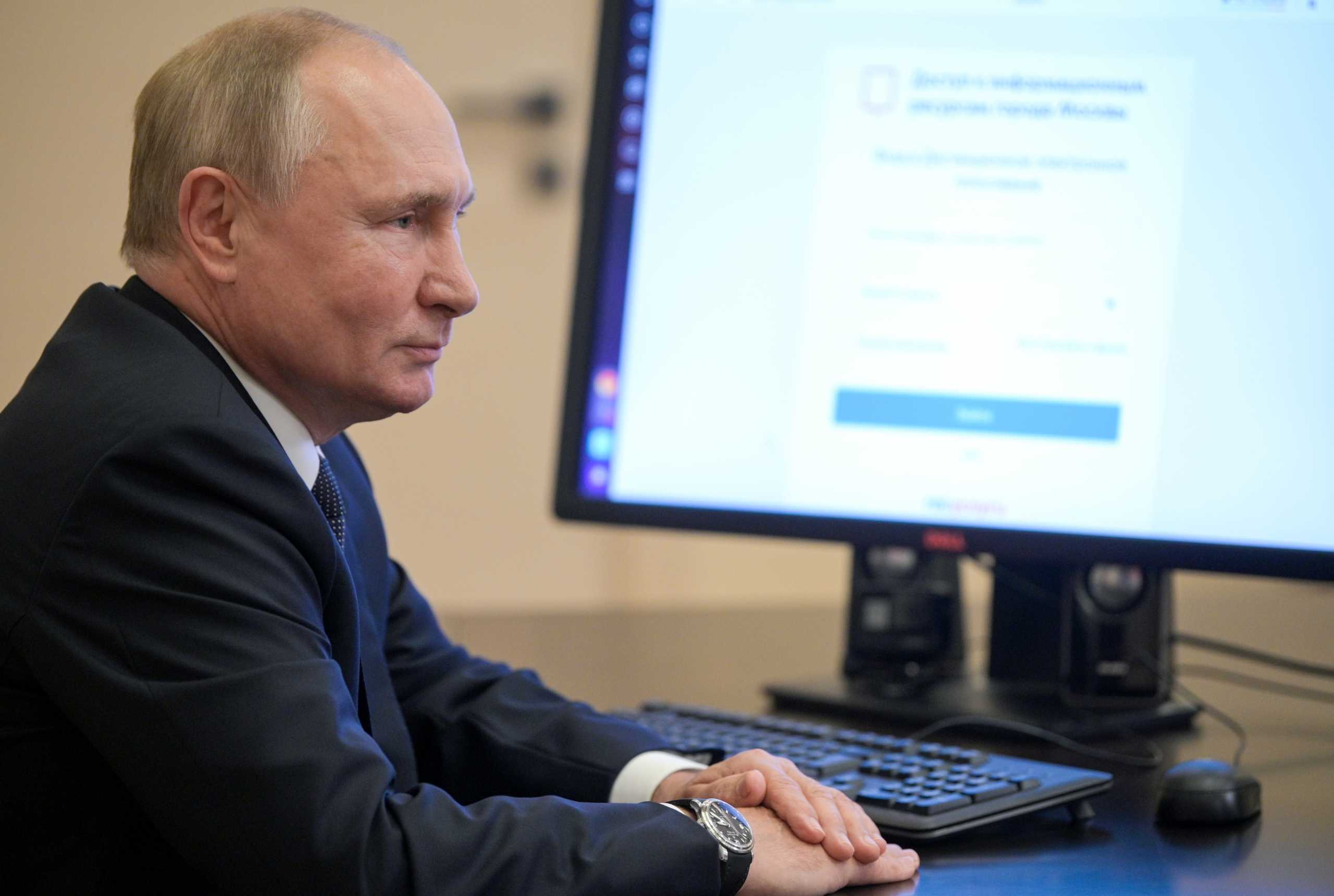 Russian President Vladimir Putin sits in front of a computer while taking part in a remote electronic voting on the first day of a three-day parliamentary election at his residence outside Moscow, Russia September 17, 2021. Sputnik