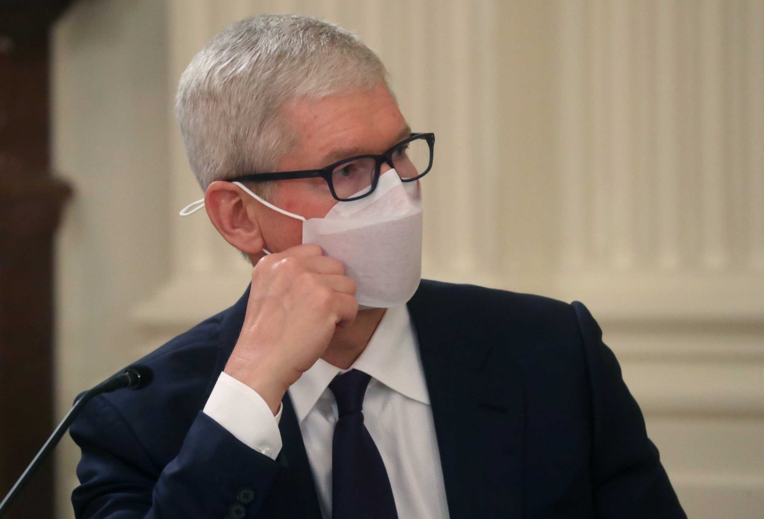 Apple Inc Chief Executive Officer Tim Cook listens as U.S. President Joe Biden delivers remarks during a meeting with members of his national security team and private sector leaders to discuss how to "improve the nation's cybersecurity," in the East Room at the White House in Washington, U.S., August 25, 2021. REUTERS
