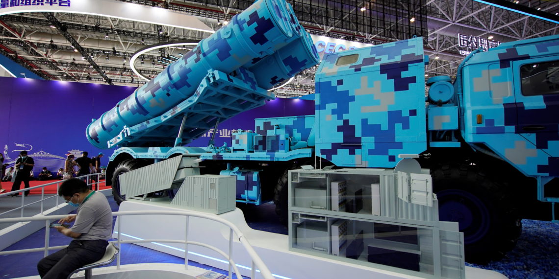 A man sits next to a model of a shore-based launch vehicle for anti-ship missiles displayed at the China International Aviation and Aerospace Exhibition, or Airshow China, in Zhuhai, Guangdong province, China September 29, 2021. REUTERS
