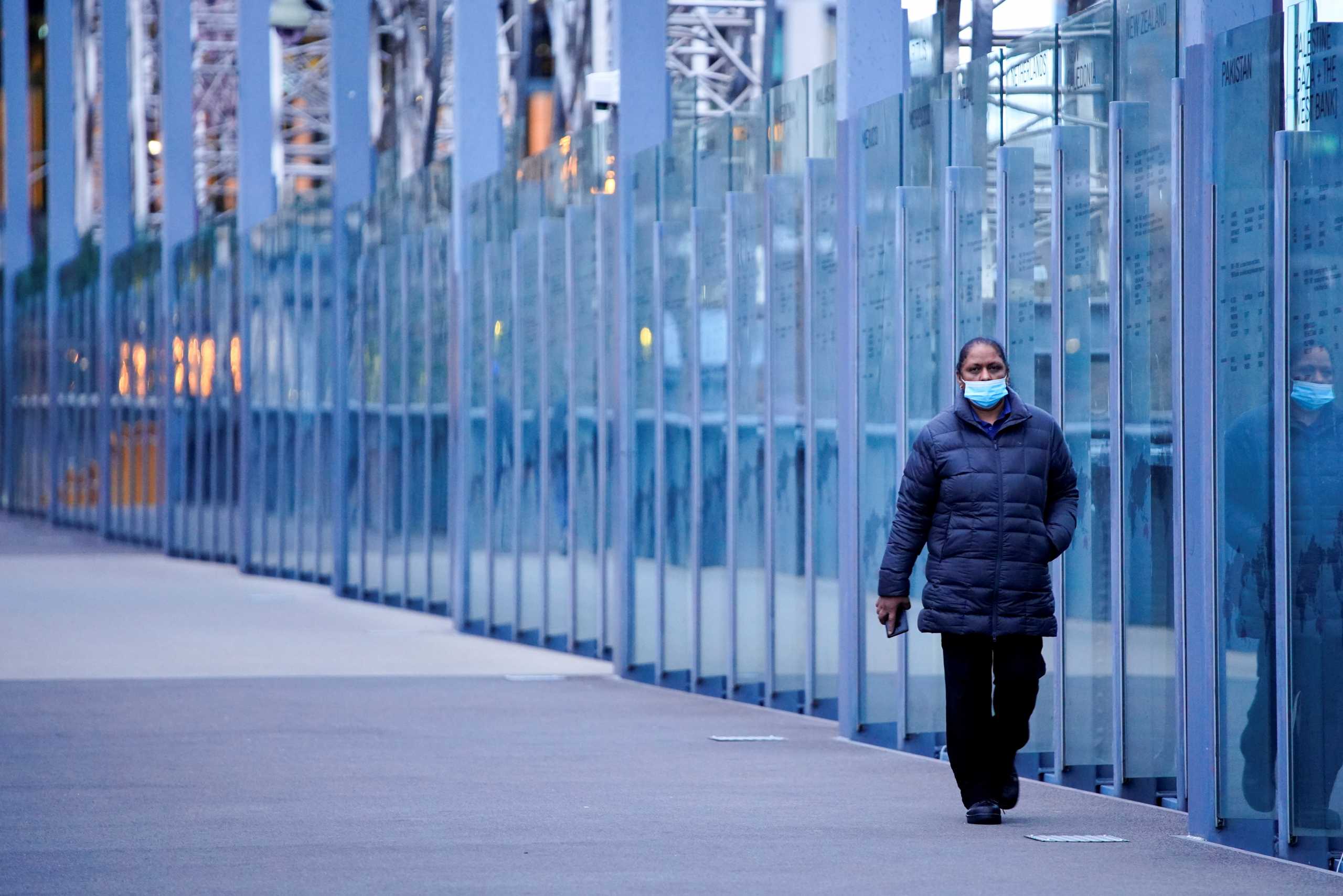 FILE PHOTO: A woman wearing a protective face mask walks along a deserted city bridge during morning commute hours on the first day of a lockdown as the state of Victoria looks to curb the spread of a coronavirus disease (COVID-19) outbreak in Melbourne, Australia, July 16, 2021.  REUTERS