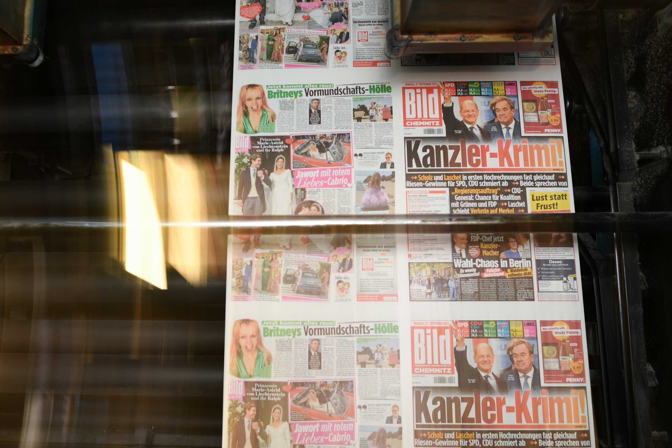 A printed edition of Bild newspaper shows candidates for chancellor Olaf Scholz, of Social Democratic Party (SPD), and Armin Laschet, of Christian Democratic Union (CDU), after the first exit polls for the general elections in Berlin, Germany, September 26, 2021. REUTERS