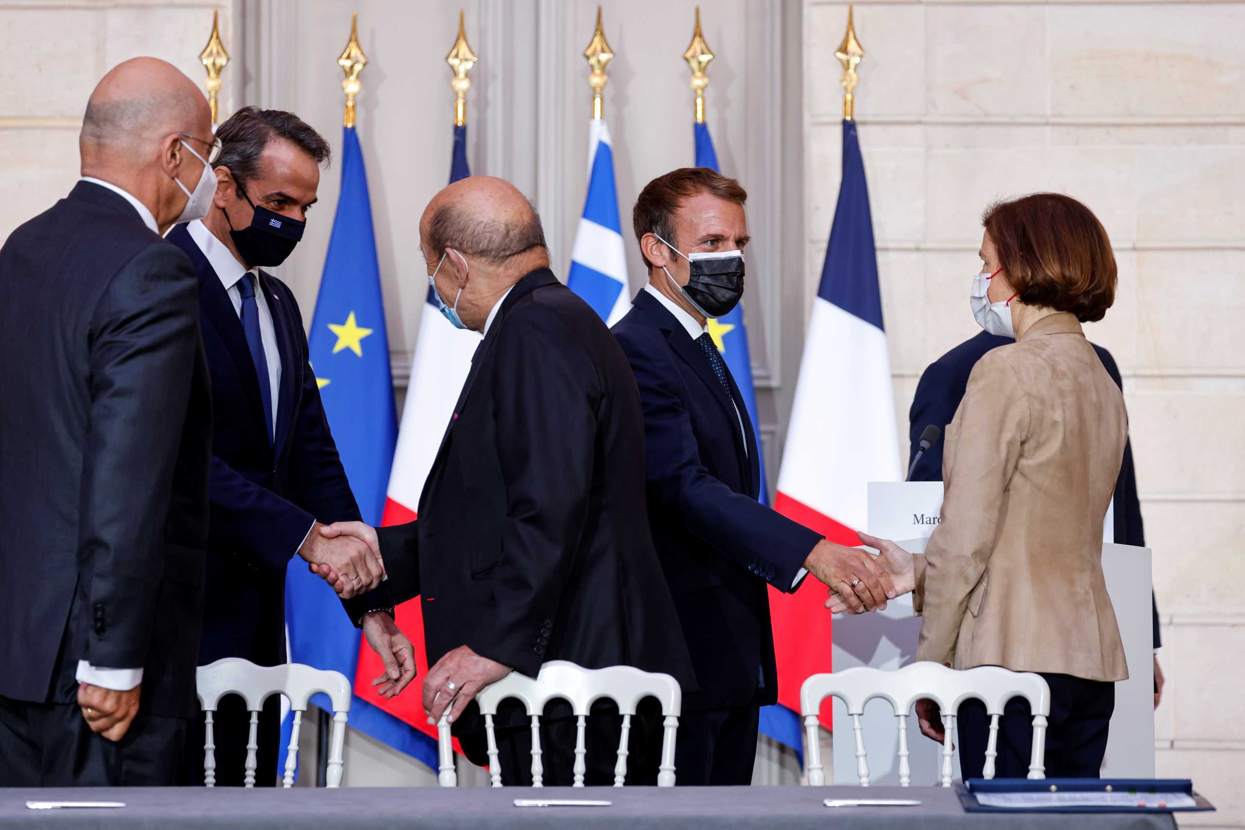 Greek Prime Minister Kyriakos Mitsotakis shakes hands with French Foreign Affairs Minister Jean-Yves Le Drian as French President Emmanuel Macron shakes hands with French Defence Minister Florence Parly next to Greek Foreign Affairs Minister Nikos Dendias during the signing ceremony of a new defence deal at The Elysee Palace in Paris, France September 28, 2021. Ludovic Marin