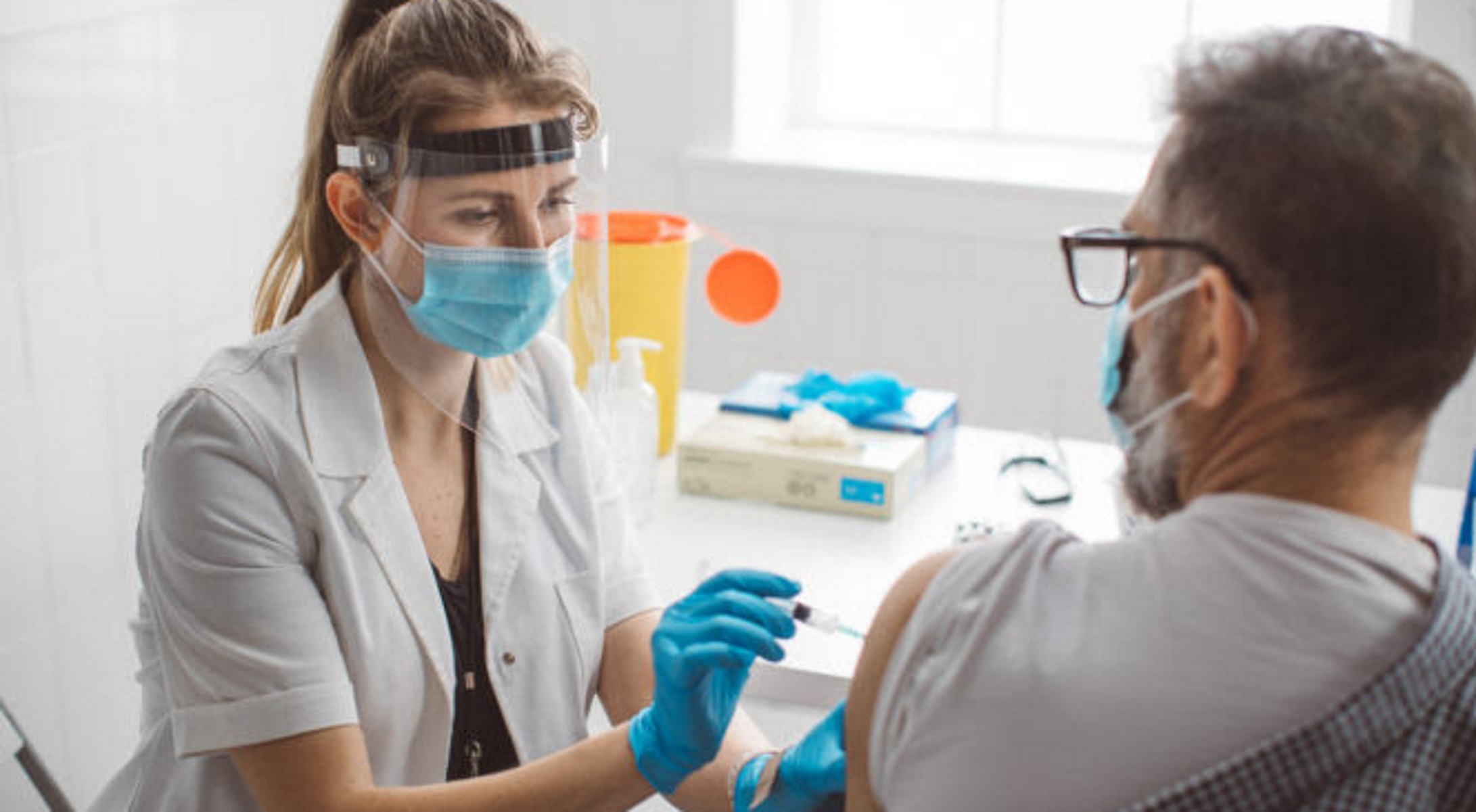 Nurse giving vaccine to mature men to make antibody for coronavirus. Virus protection. COVID-2019.