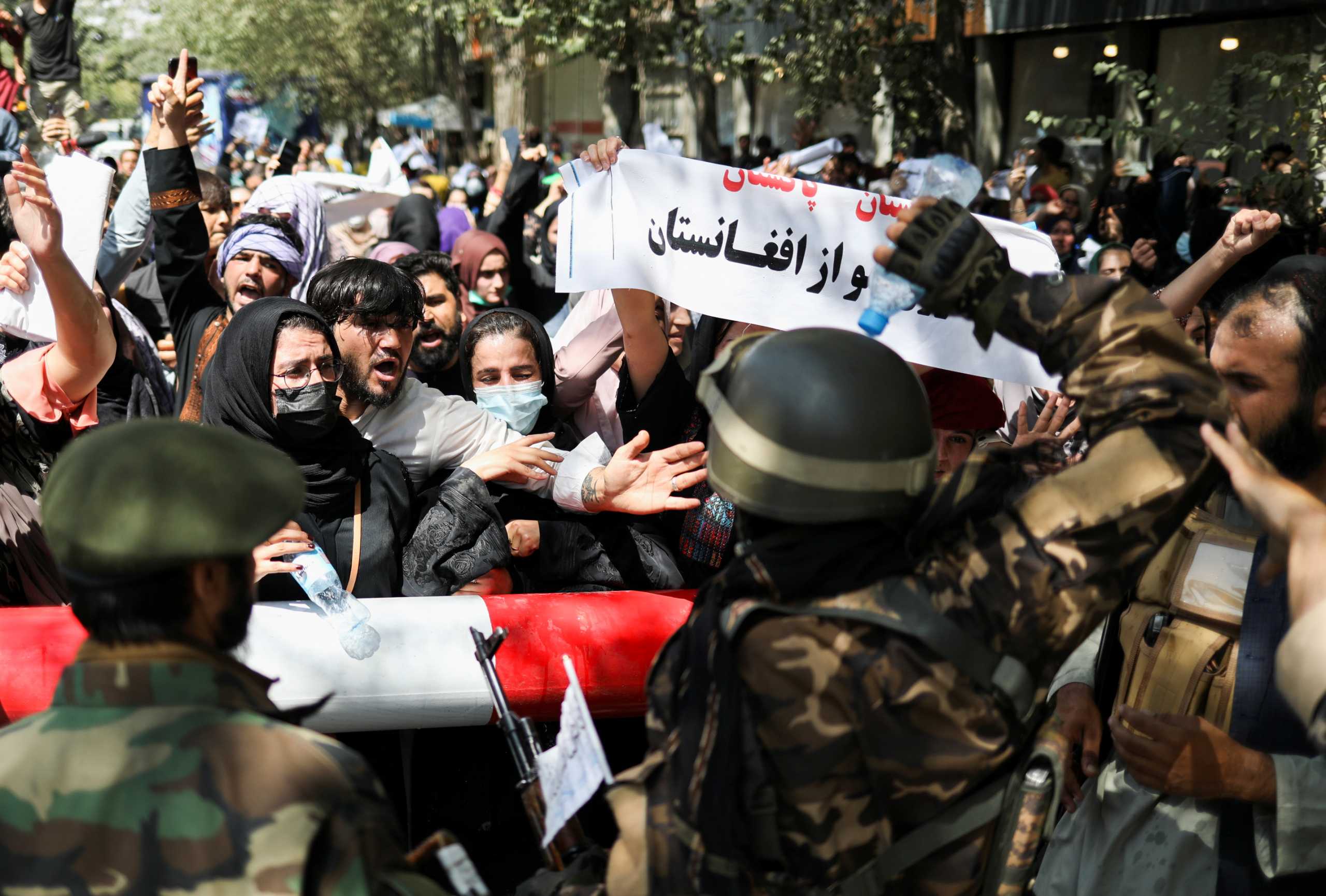 Taliban soldiers stand in front of protesters during the anti-Pakistan protest in Kabul, Afghanistan, September 7, 2021. WANA (West Asia News Agency) via REUTERS ATTENTION EDITORS - THIS IMAGE HAS BEEN SUPPLIED BY A THIRD PARTY.