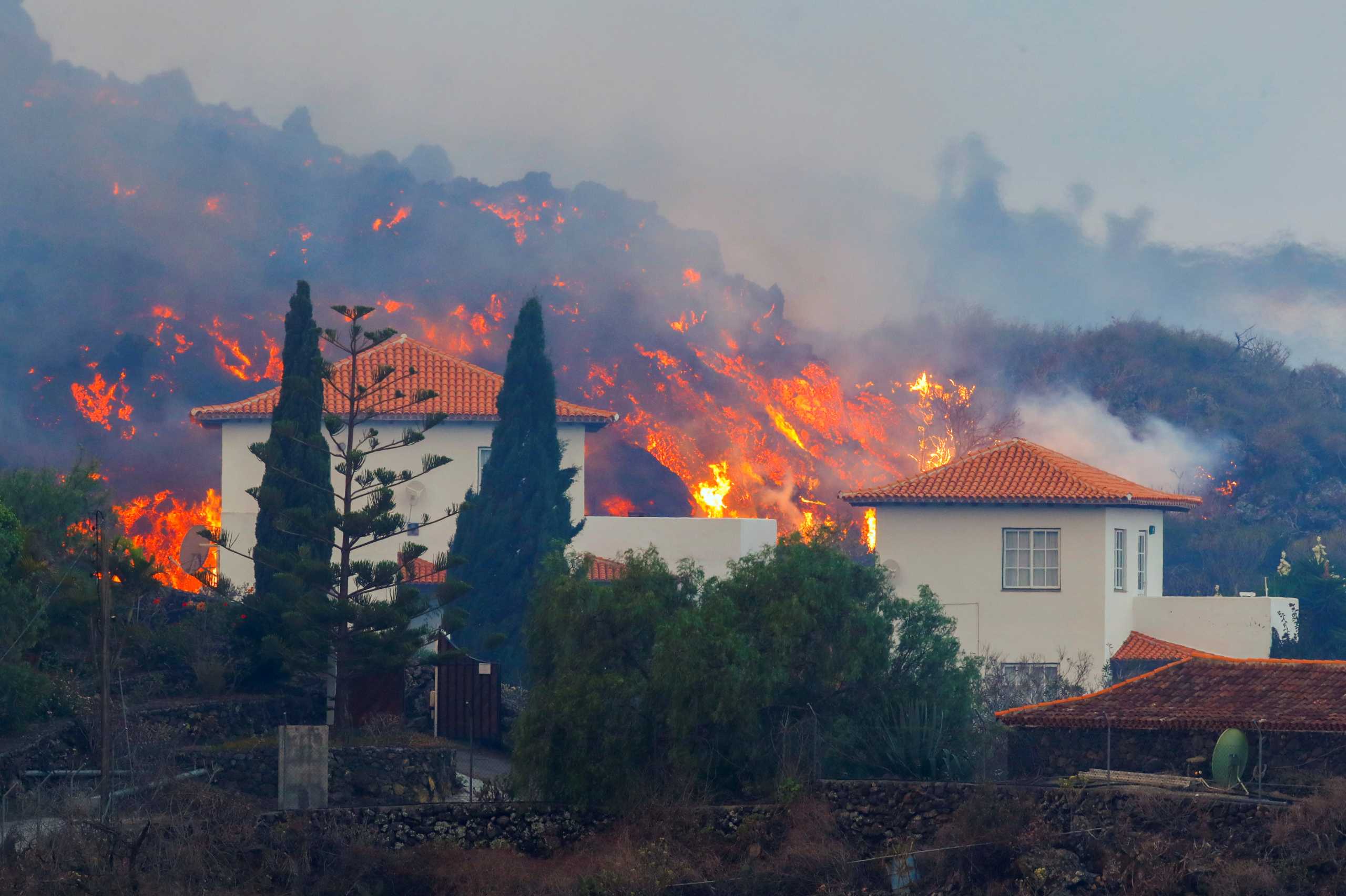 Lava flows behind a house following the eruption of a volcano in the Cumbre Vieja national park at Los Llanos de Aridane, on the Canary Island of La Palma, September 20, 2021. REUTERS