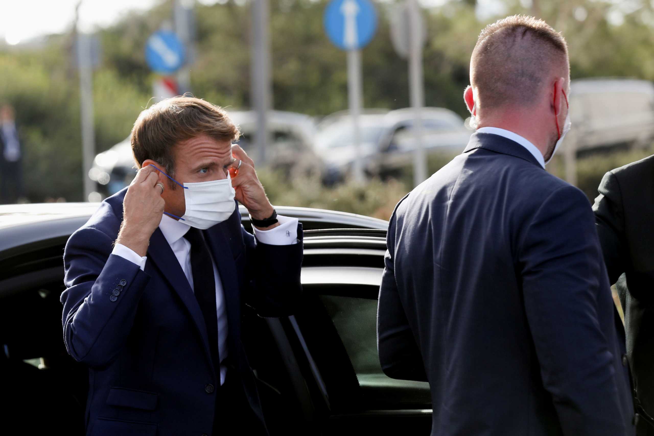 French President Emmanuel Macron puts on his face mask as he arrives for the 8th MED7 Mediterranean countries summit, in Athens, Greece, September 17, 2021. REUTERS