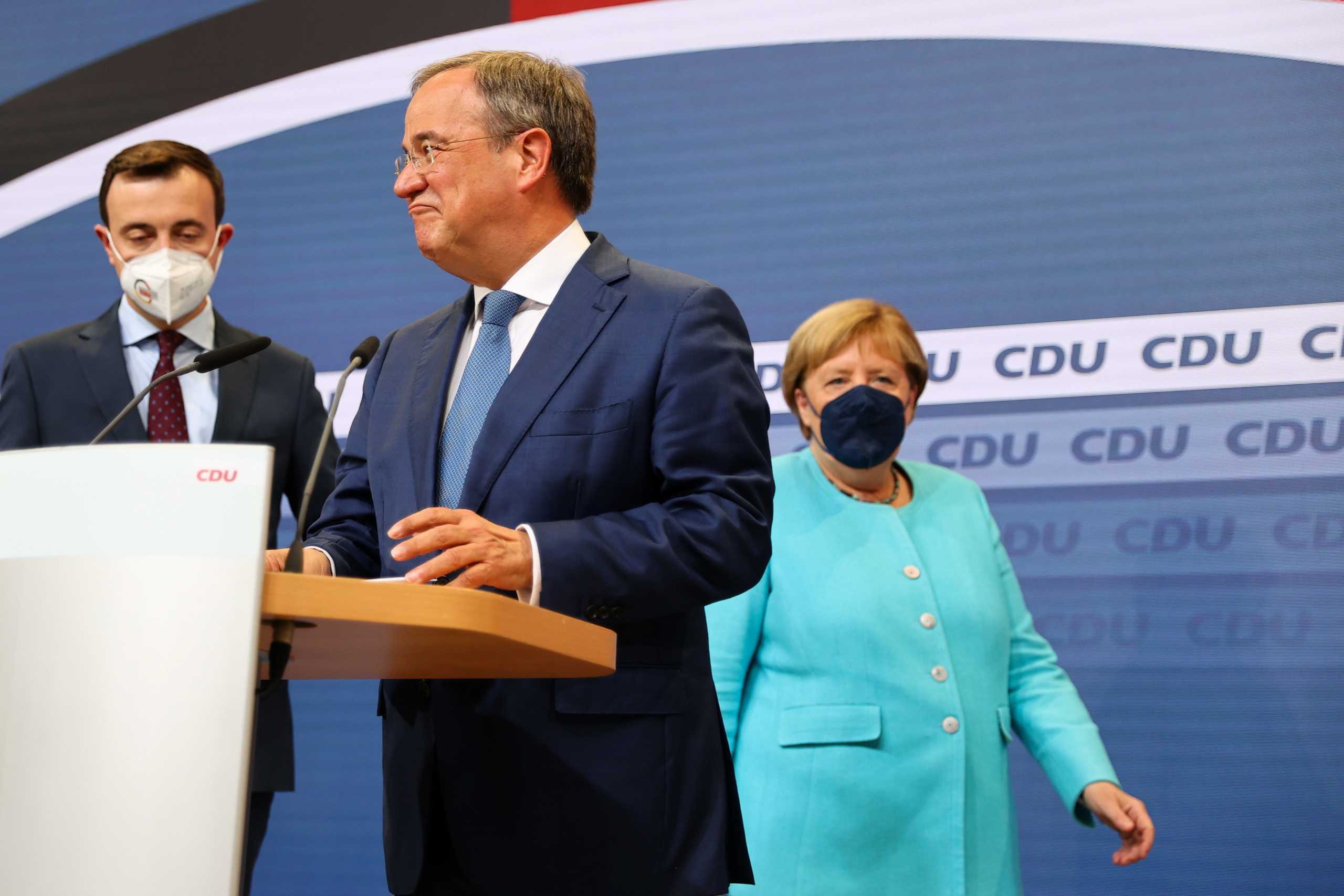 Christian Democratic Union (CDU) leader and top candidate for chancellor Armin Laschet and German Chancellor Angela Merkel appear after first exit polls for the general elections in Berlin, Germany, September 26, 2021. REUTERS