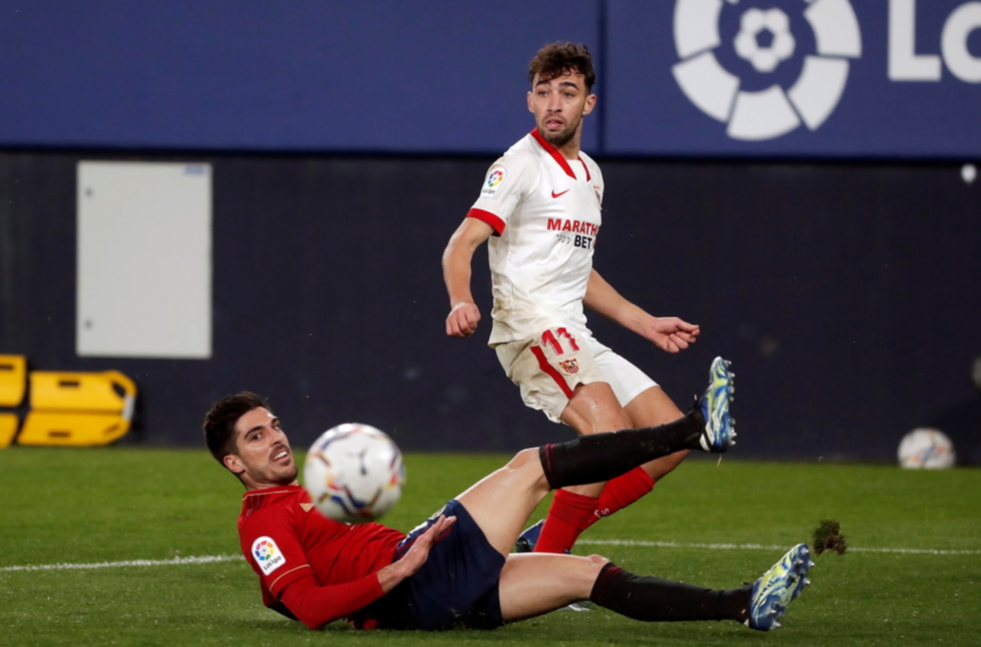 epa09030467 Sevilla's Munir El Haddadi (R) in action against Nacho Vidal (L) of Osasuna during a Spanish LaLiga soccer match between Osasuna and Sevilla FC at El Sadar stadium in Pamplona, Navarra, northern Spain, 22 February 2021.  EPA