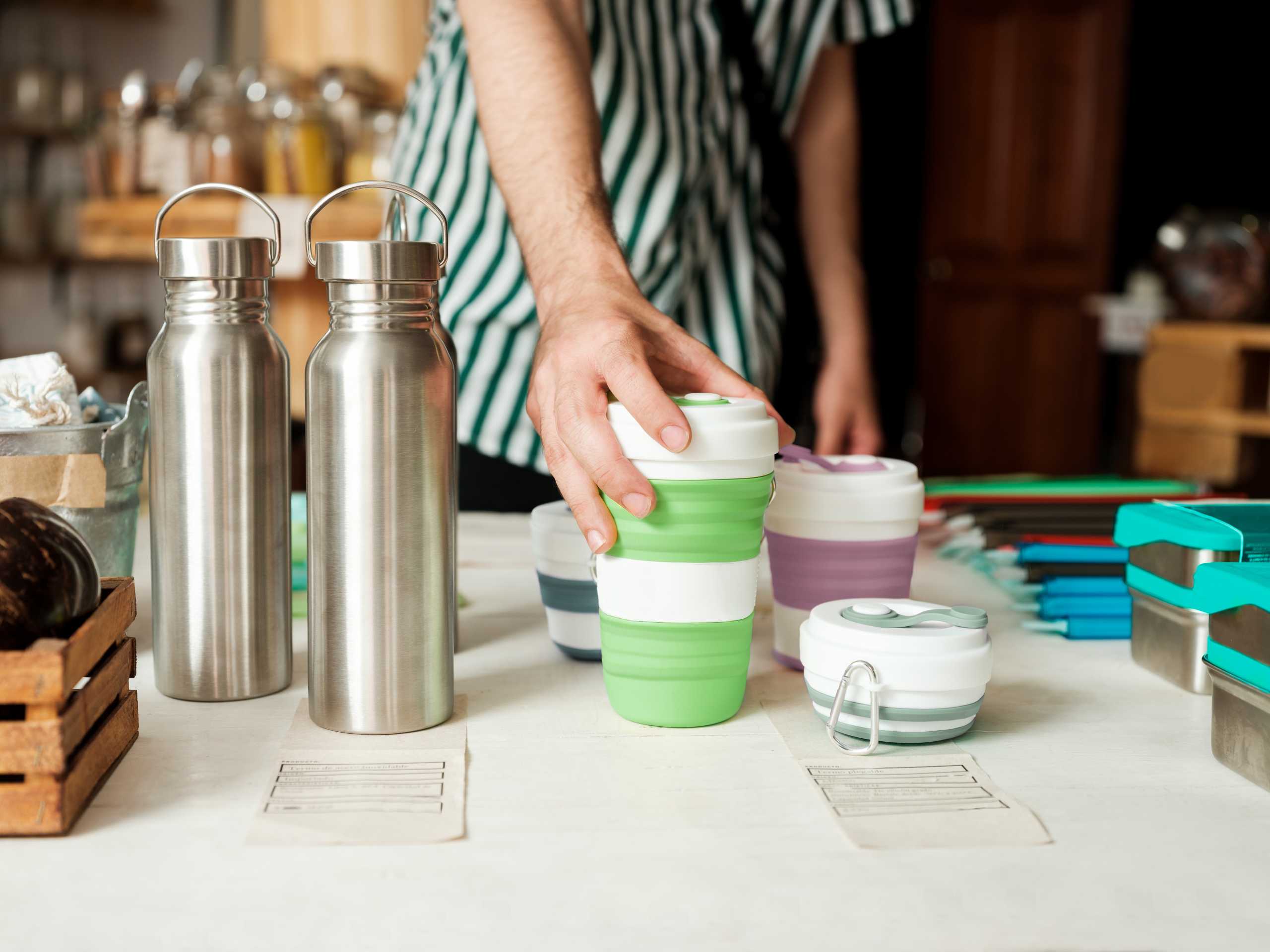 Latin man holding reusable bottle in zero waste shop