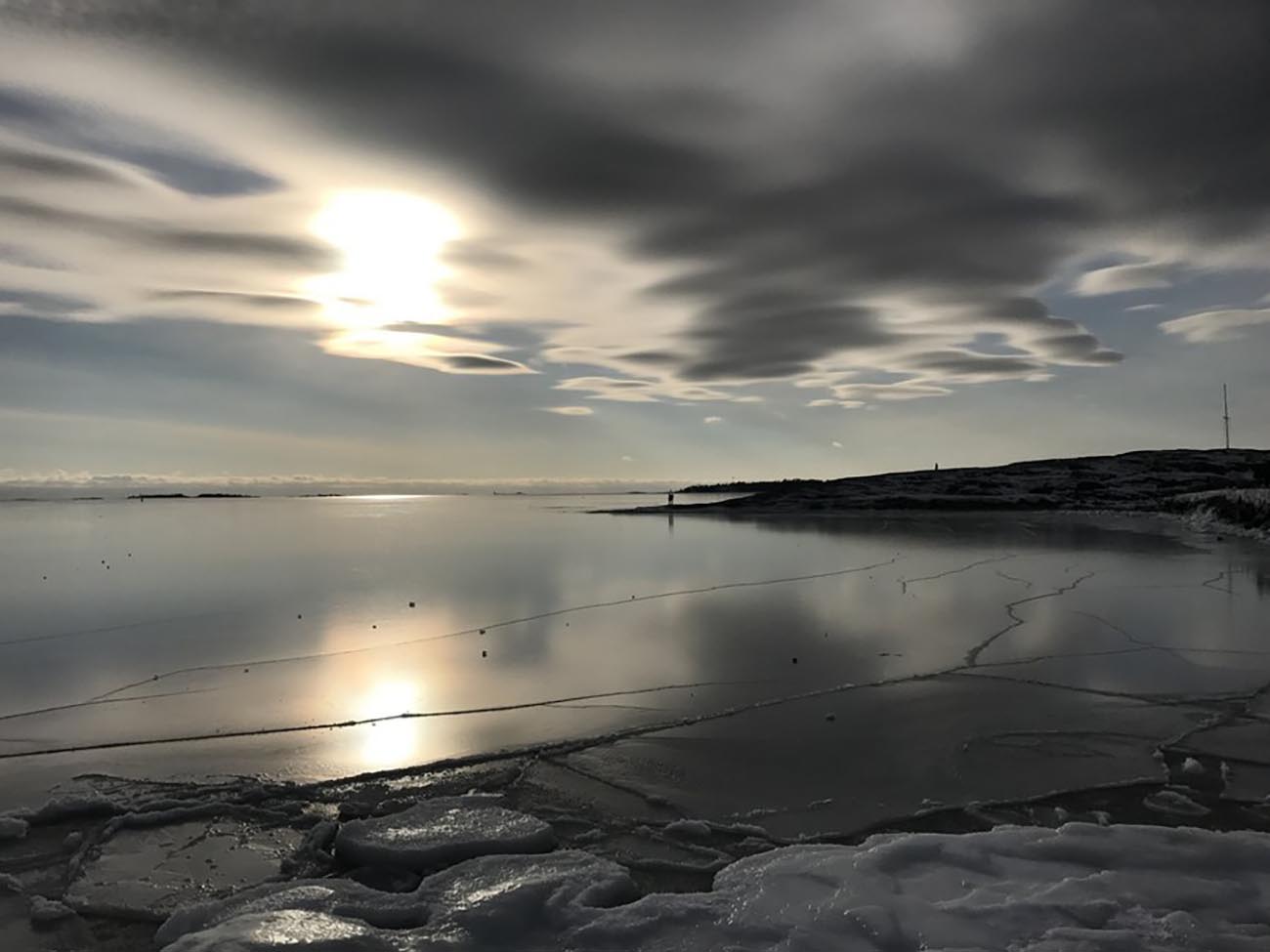 epa05788372 A couple (C) stands on the cliffs of an island at the frozen shoreline in Helsinki, Finland, 12 February 2017. Weather forecasts predict a turn to warmer temperatures from below zero, as a warm front approaches from Norway's coast and across Sweden.  EPA
