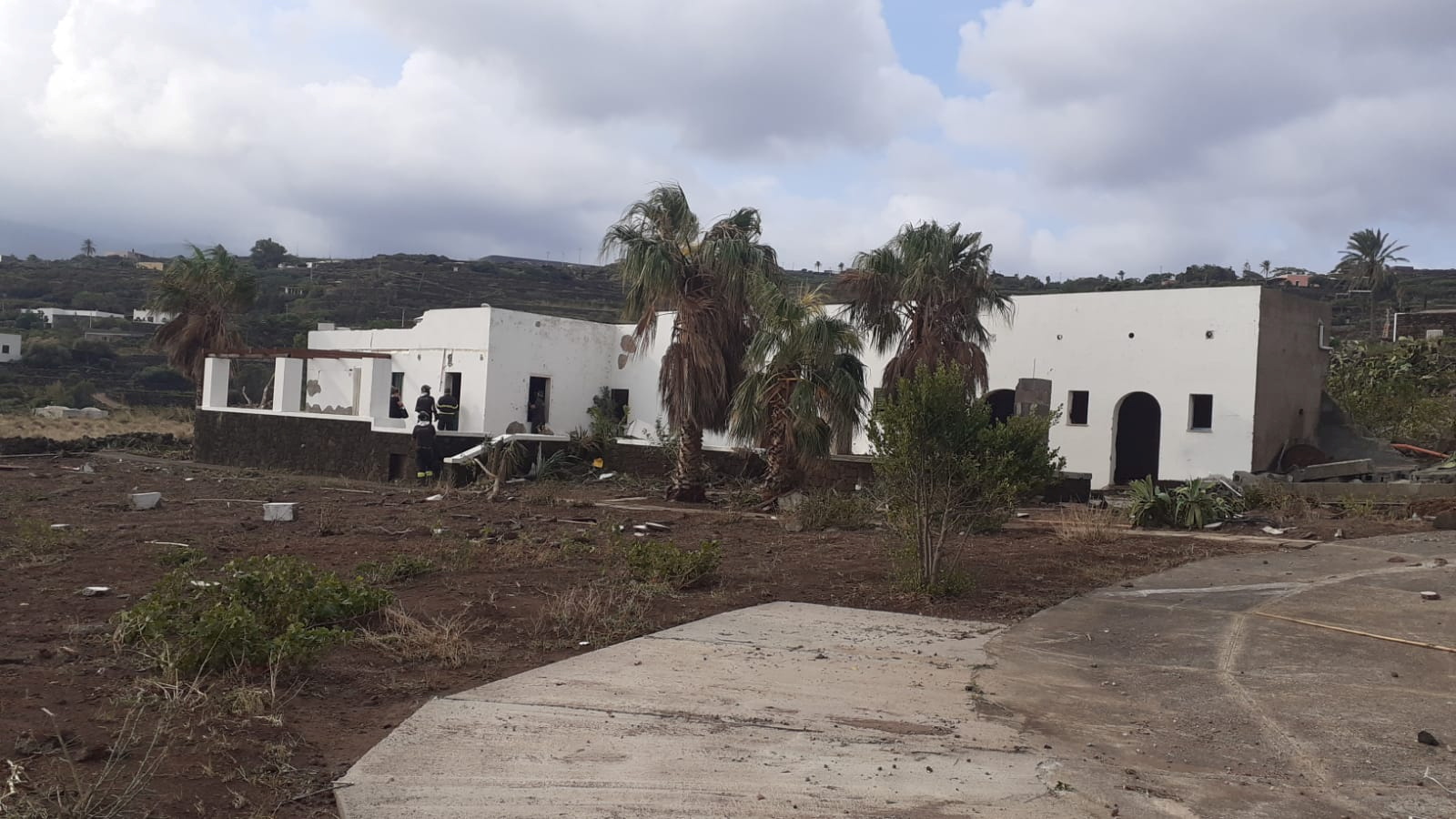 Firefighters inspect a damaged building after a tornado hit the small Italian island of Pantelleria,, Italy, September 11, 2021. Italian Civil Protection Agency