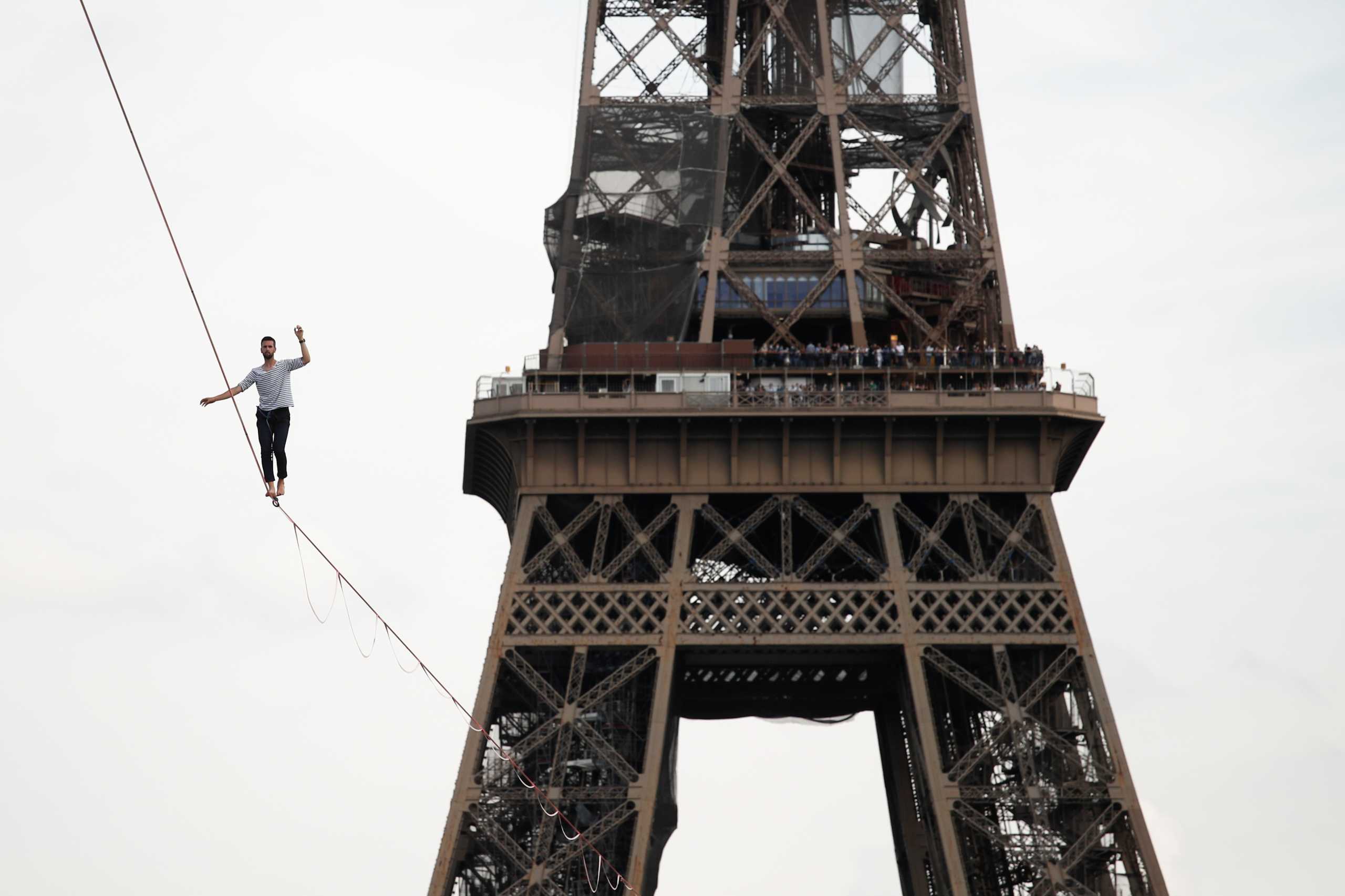 French acrobat Nathan Paulin walks on a slackline between the Eiffel Tower and the Theatre National de Chaillot as part of events around France for National Heritage Day in Paris, France, September 18, 2021. REUTERS