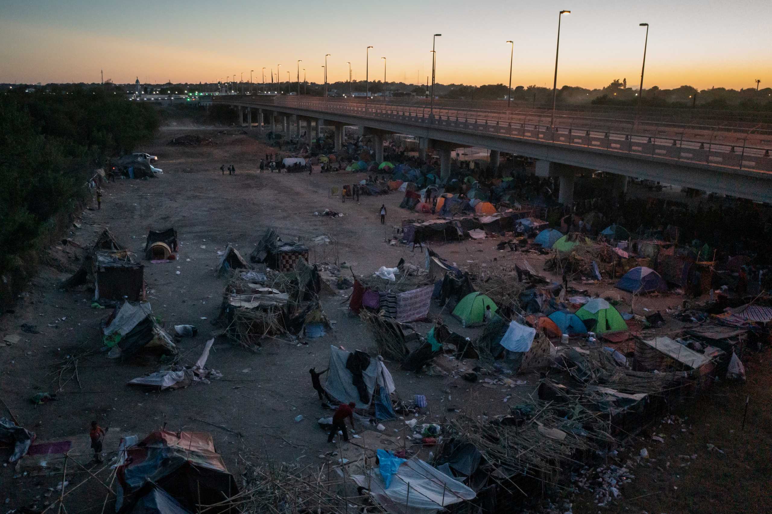 A migrant pulls down his shelter at the makeshift border camp along the International Bridge in Del Rio, Texas, U.S. September 23, 2021. REUTERS