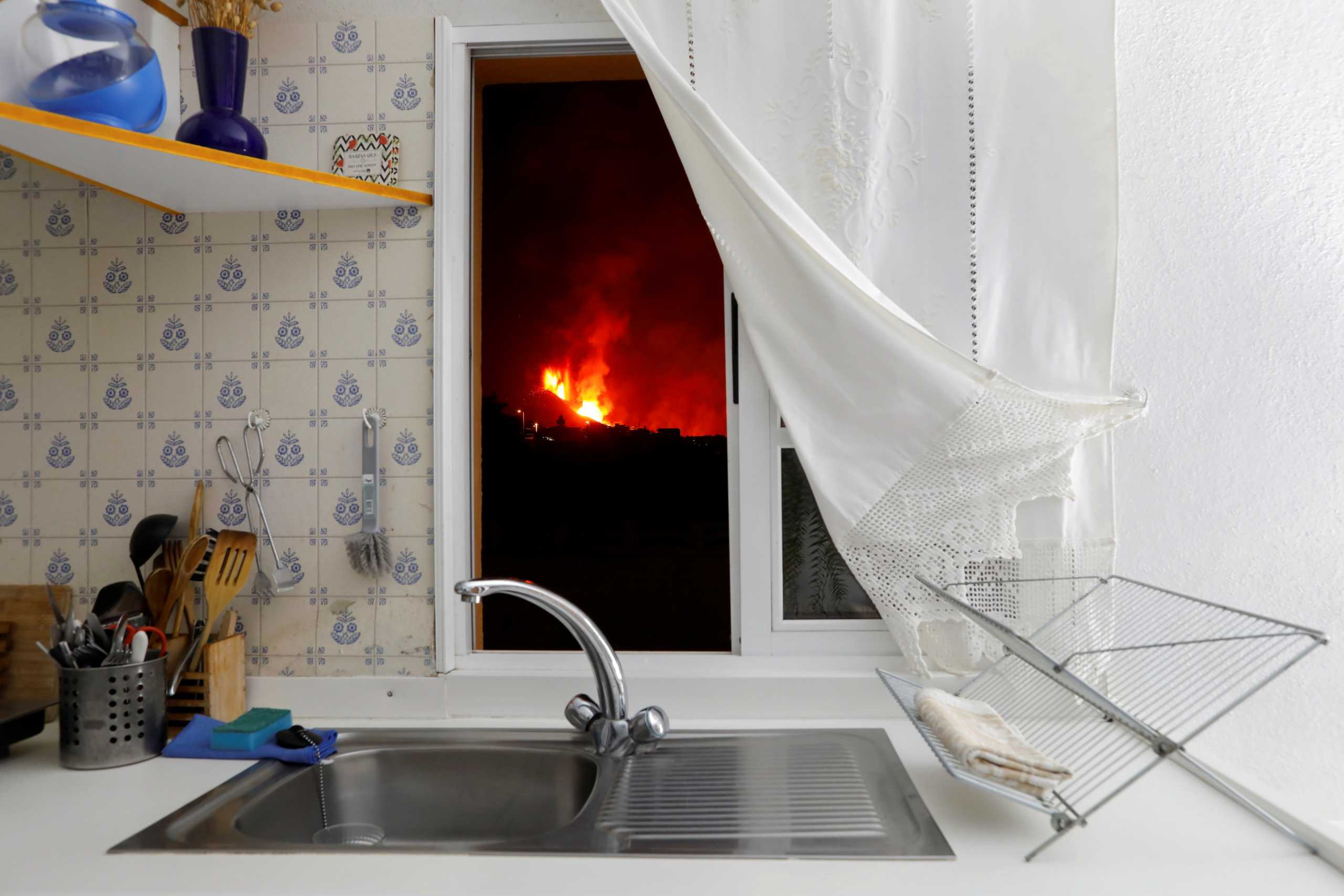 Lava is seen through the window of a kitchen from El Paso following the eruption of a volcano on the Canary Island of La Palma, Spain, September 28, 2021. REUTERS