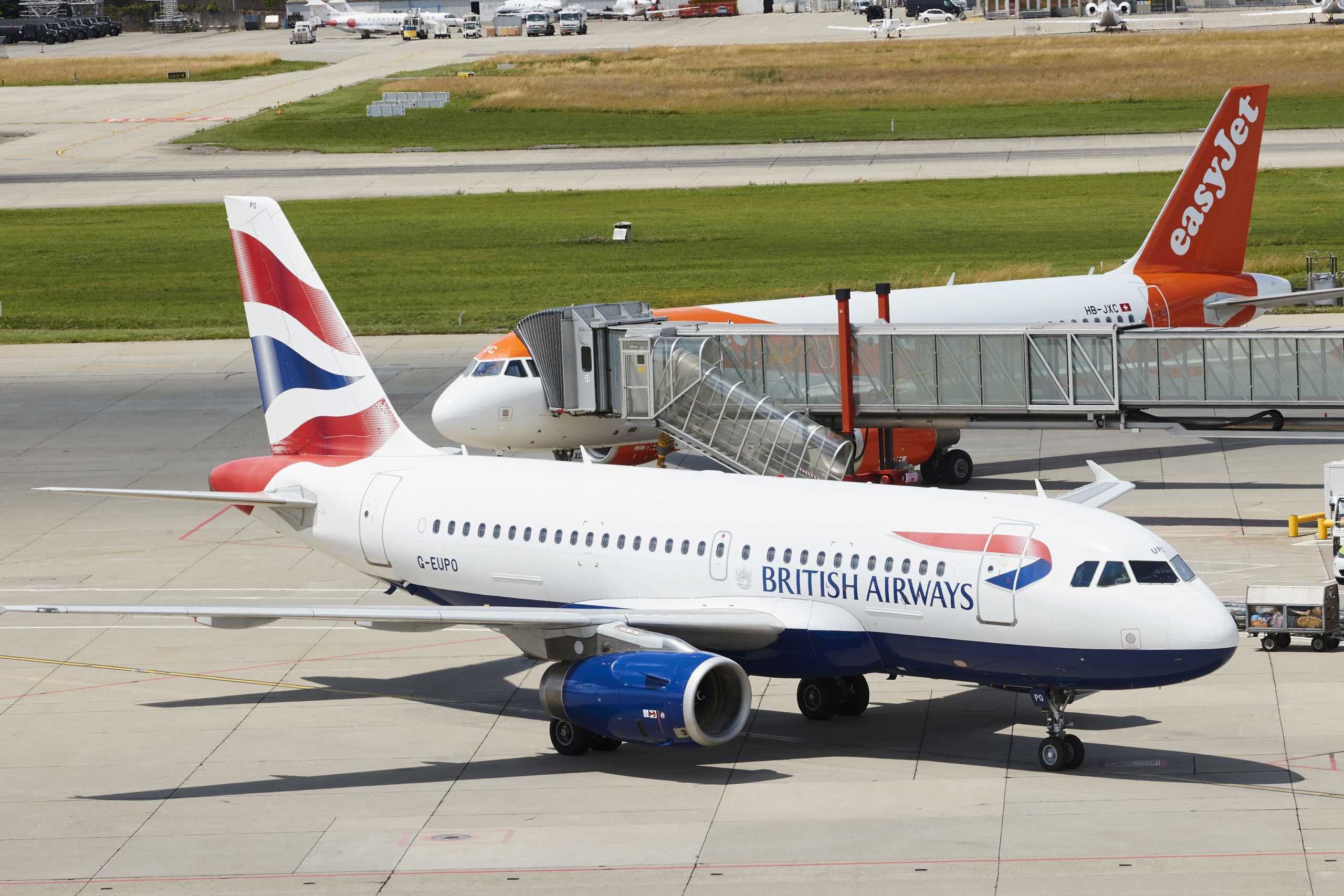 FILE PHOTO: A British Airways aircraft parks next to an EasyJet plane at Cointrin airport in Geneva, Switzerland June 24, 2021.  REUTERS