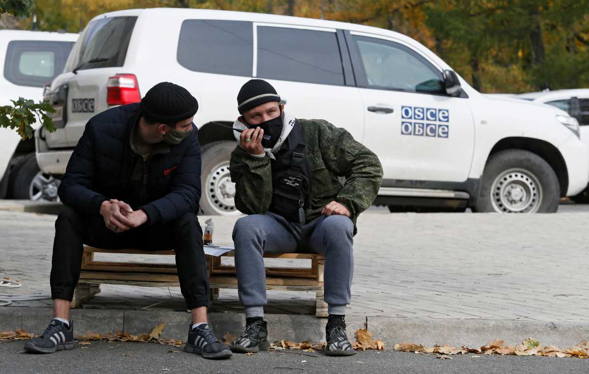 Protesters are seen in front of the Park Inn hotel housing OSCE monitor mission during a rally to demand the release of a pro-Russian officer, captured by the Ukrainian military this week, in the rebel-controlled city of Donetsk, Ukraine October 17, 2021. REUTERS