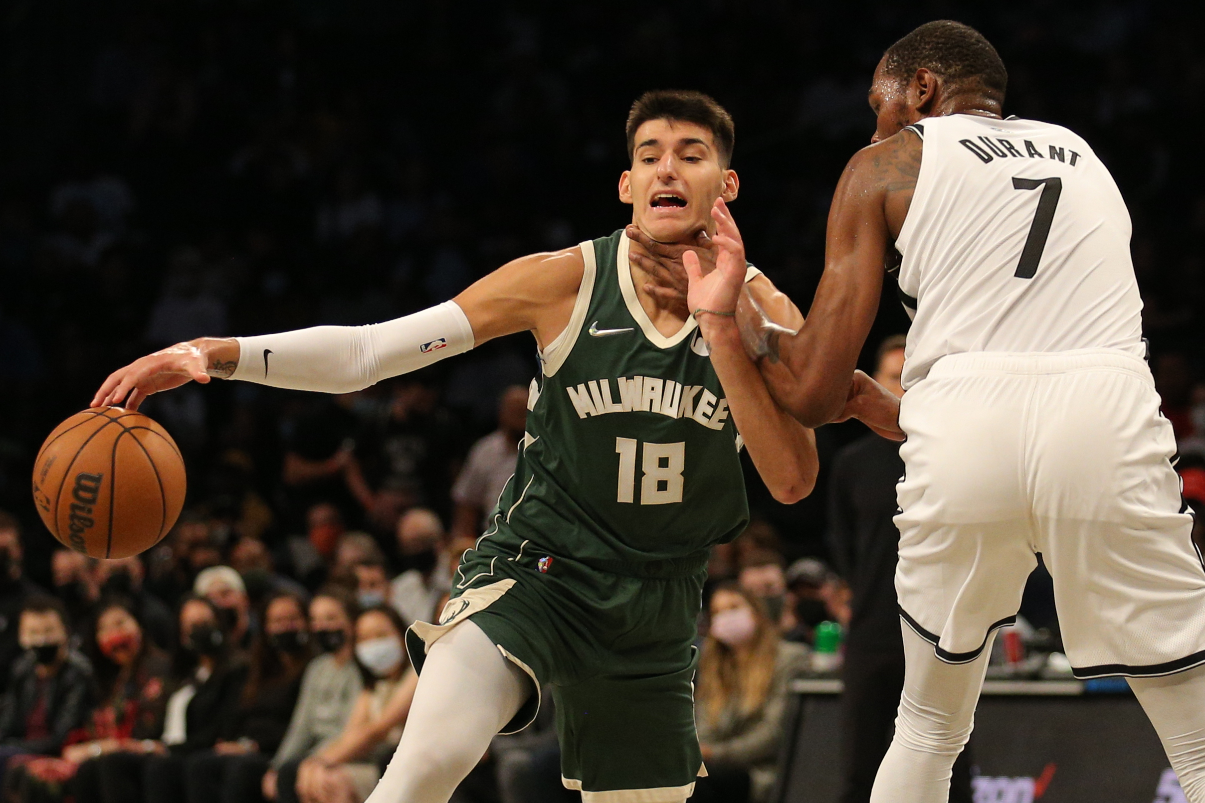 Oct 8, 2021; Brooklyn, New York, USA; Milwaukee Bucks forward Georgios Kalaitzakis (18) is fouled as he drives around Brooklyn Nets forward Kevin Durant (7) during the third quarter at Barclays Center. Mandatory Credit: Brad Penner-USA TODAY Sports