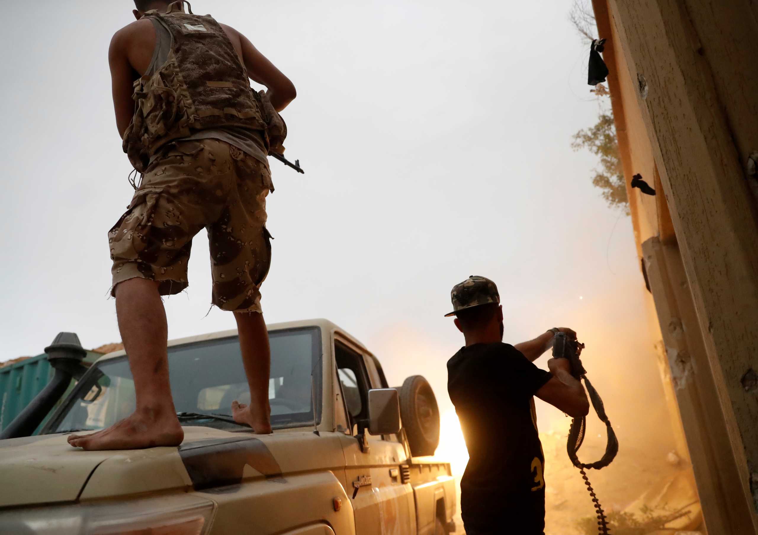 FILE PHOTO: Fighters loyal to Libya's U.N.-backed government (GNA) fire guns during clashes with forces loyal to Khalifa Haftar on the outskirts of Tripoli, Libya May 25, 2019. REUTERS