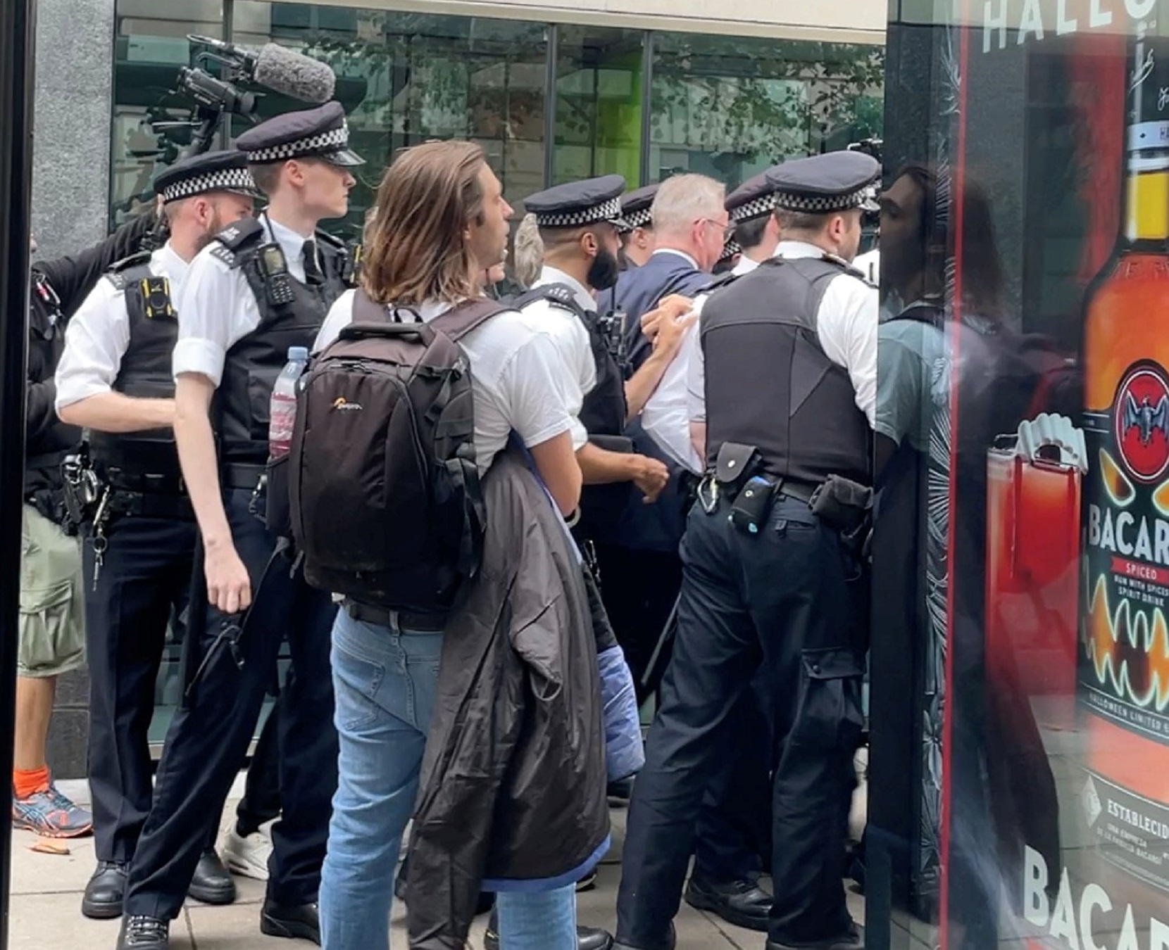 Britain's Housing Secretary Michael Gove walks while surrounded by police officers and protesters, in London, Britain October 19, 2021, in this still image obtained from a social media video. Paul Brown