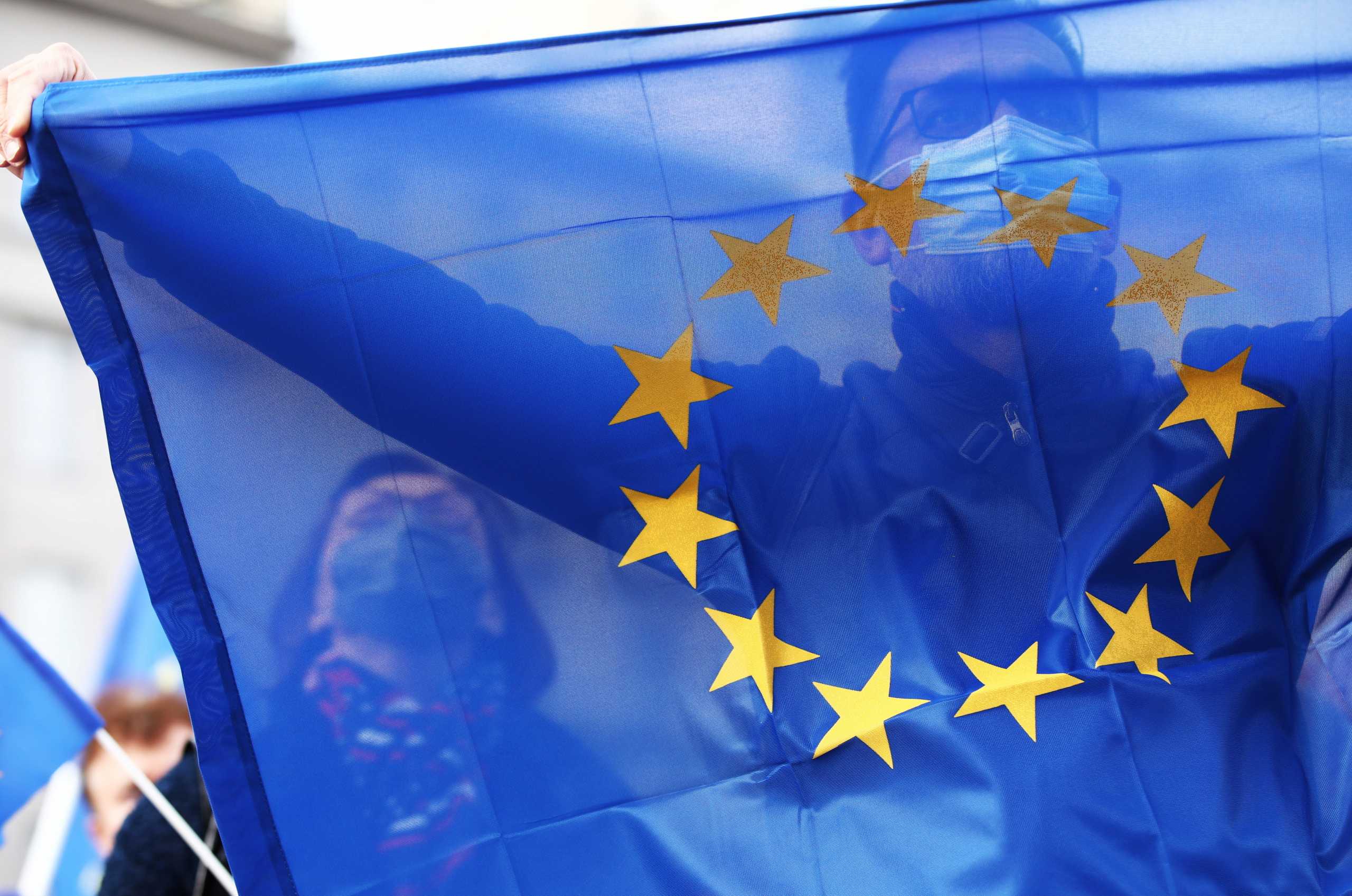A demonstrator wearing a face mask holds the EU flag during a rally in support of Poland's membership in the European Union after the country's Constitutional Tribunal ruled on the primacy of the constitution over EU law, undermining a key tenet of European integration, in Krakow, Poland, October 10, 2021. Jakub Wlodek
