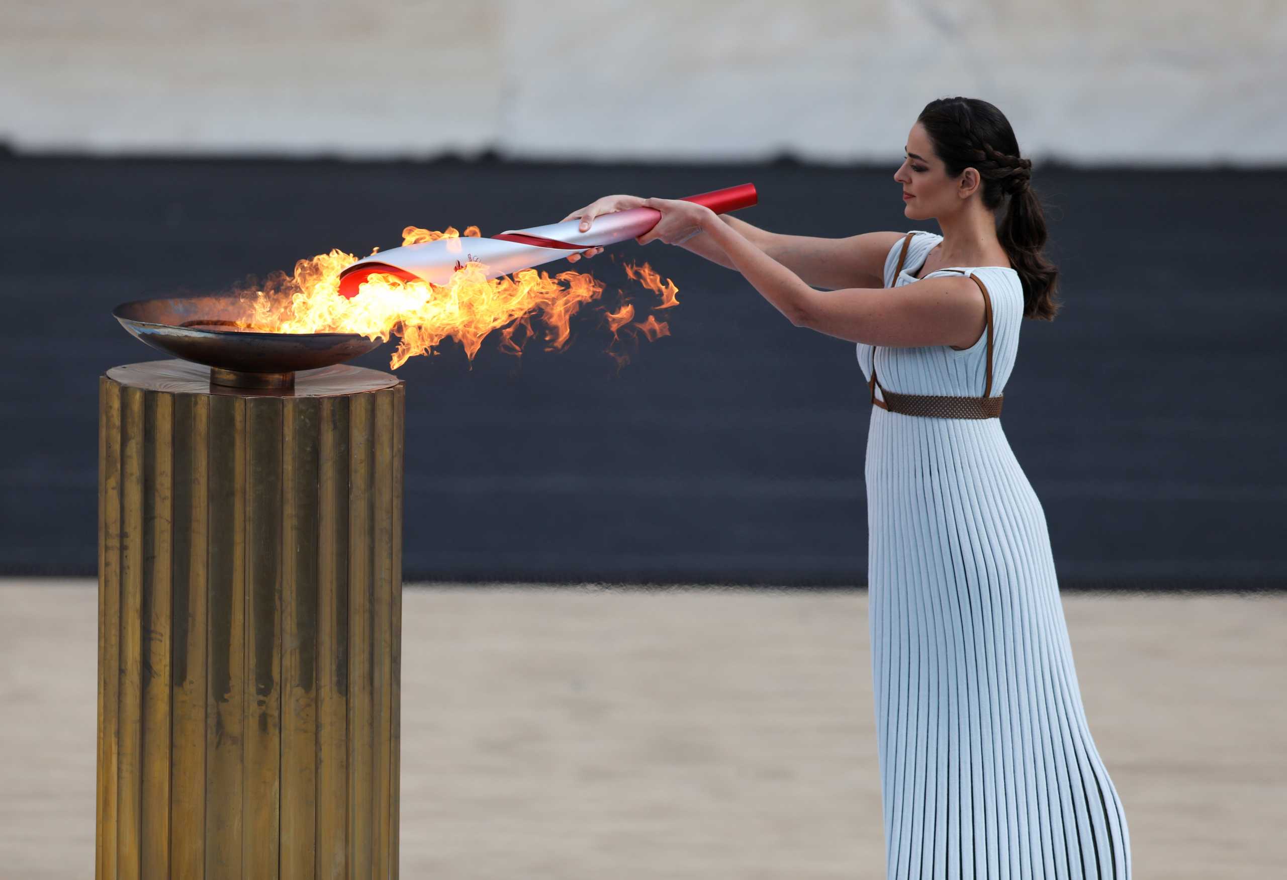 Winter Olympics - Flame handover ceremony in Athens for the Beijing 2022 Winter Olympics - Panathenaic Stadium, Athens, Greece - October 19, 2021 Greek actress Xanthi Georgiou, playing the role of High Priestess lights the torch with the flame during the ceremony REUTERS