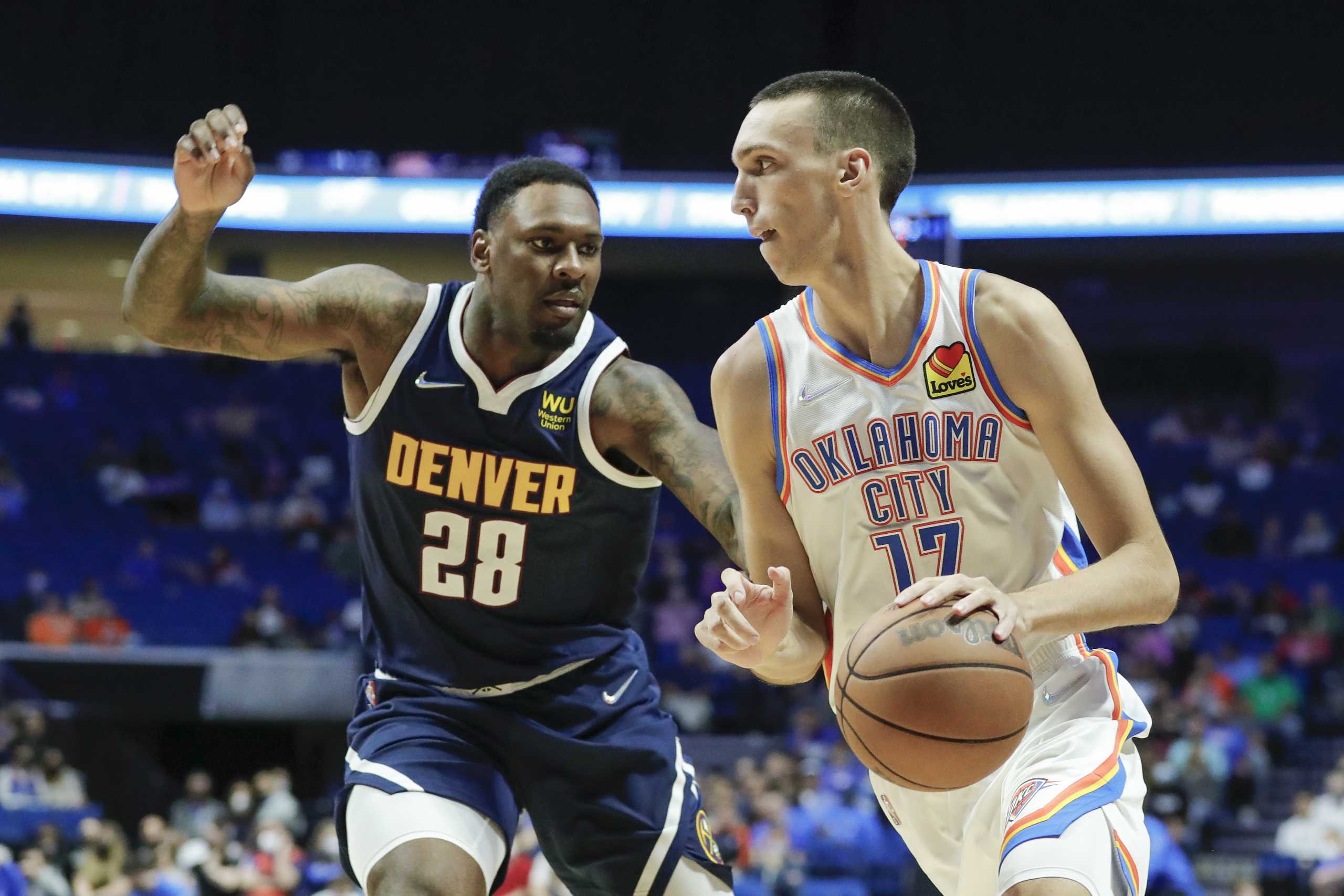 Oct 14, 2021; Tulsa, Oklahoma, USA; Oklahoma City Thunder forward Aleksej Pokusevski (17) drives to the basket around Denver Nuggets forward Tarik Black (28) during the second half at BOK Center. Denver won 113-107 in overtime. Mandatory Credit: Alonzo Adams-USA TODAY Sports