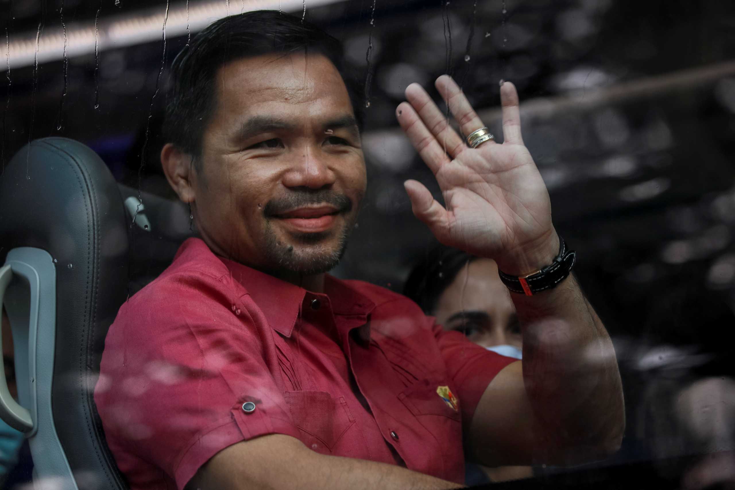 Philippine senator and newly retired boxing icon Manny Pacquiao waves from his bus before filing his certificate of candidacy for president, in Pasay City, Metro Manila, Philippines, October 1, 2021. REUTERS