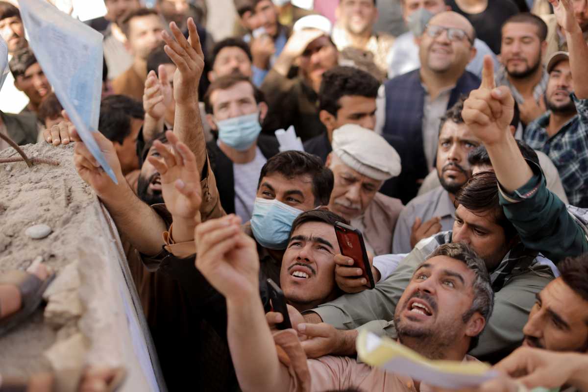 Afghans gather outside the passport office after Taliban officials announced they will start issuing passports to its citizens again, following months of delays that hampered attempts by those trying to flee the country after the Taliban seized control, in Kabul, Afghanistan October 6, 2021. REUTERS