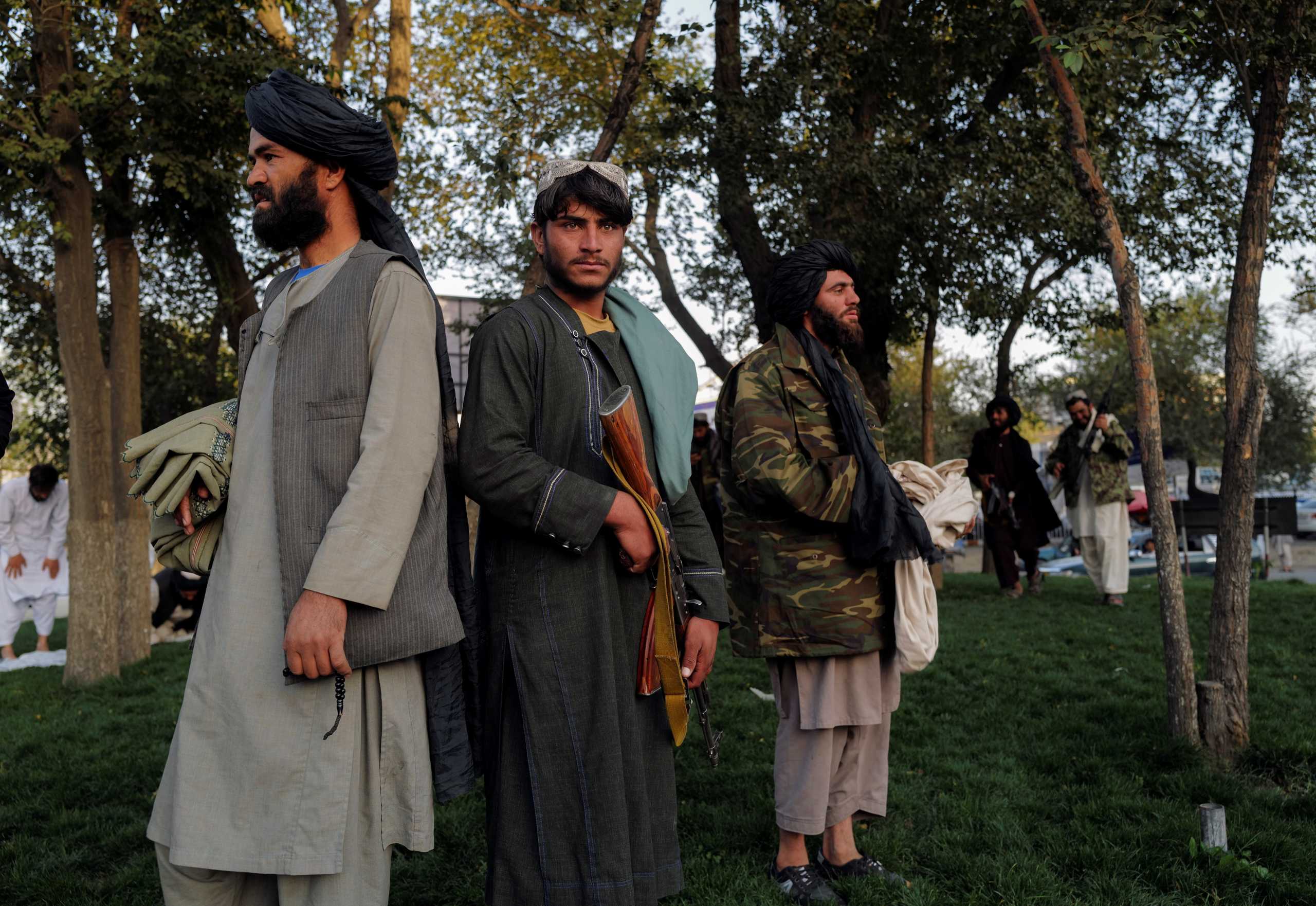 Taliban fighters stand while their comrades are praying at Deh Bori square in Kabul, Afghanistan October 18, 2021. REUTERS