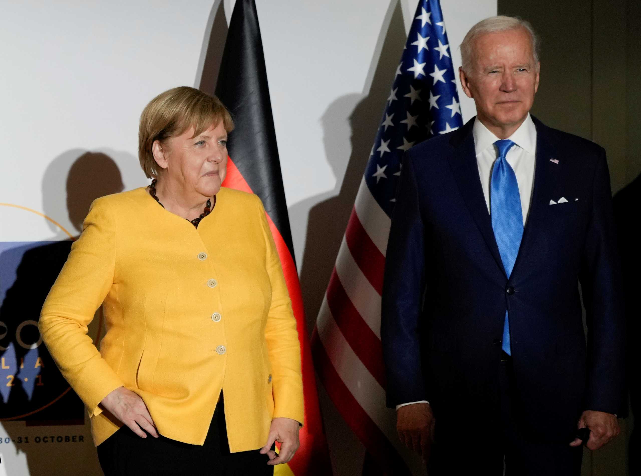 Germany's Chancellor Angela Merkel and U.S. President Joe Biden pose the media prior to a meeting during the G20 leaders' summit in Rome, Italy October 30, 2021. Kirsty Wigglesworth