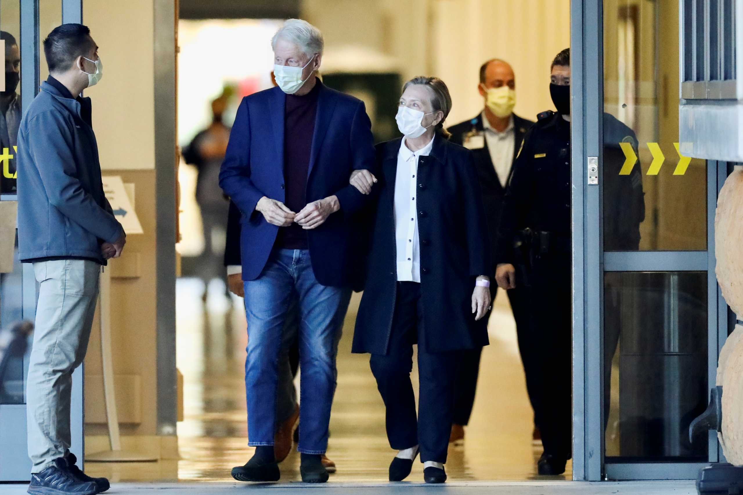 Former U.S. President Bill Clinton, accompanied by his wife, former Secretary of State Hillary Clinton, walks out of University of California Irvine Medical Center, in Orange, California, U.S. October 17, 2021.  REUTERS